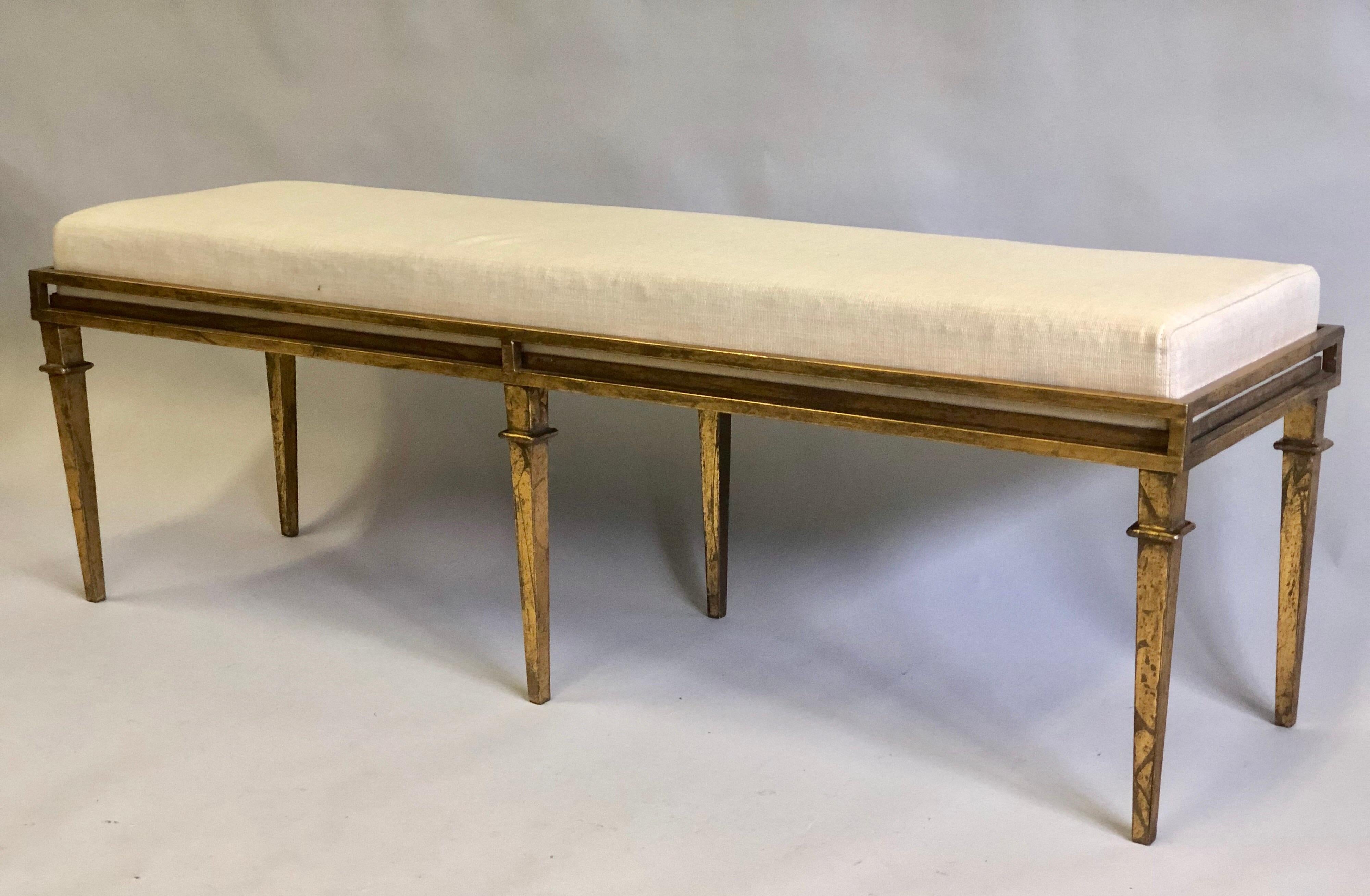 Elegant French Custom Mid-Century Modern Neoclassical style gilt iron bench in the style of Maison Ramsay. The piece is unique in design and construction: a stunning 6-leg gilt iron bench with each leg tapered, and the seat inset into the frame. The