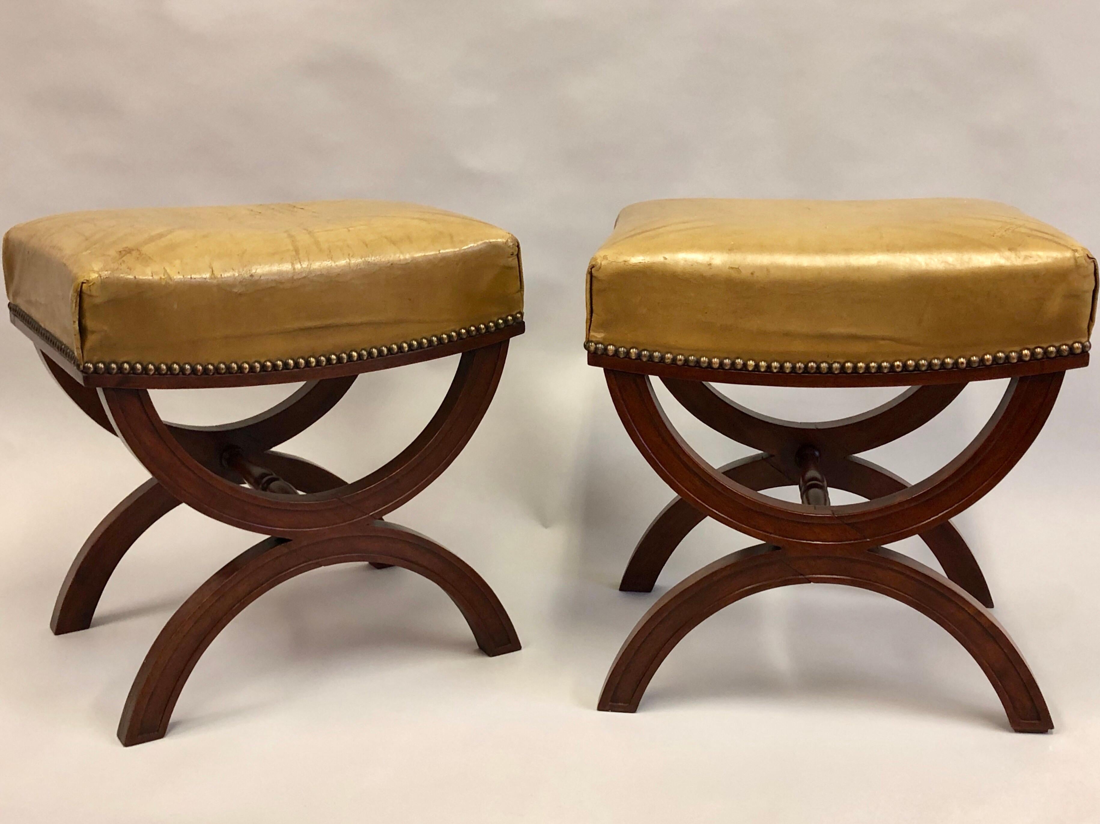 Elegant, timeless pair of French Mid-Century Modern neoclassical mahogany and leather benches or stools attributed to Andre Arbus, circa 1930. The pieces feature Classic X-frame leg structure and are delicately channelled to provide sober detailing.
