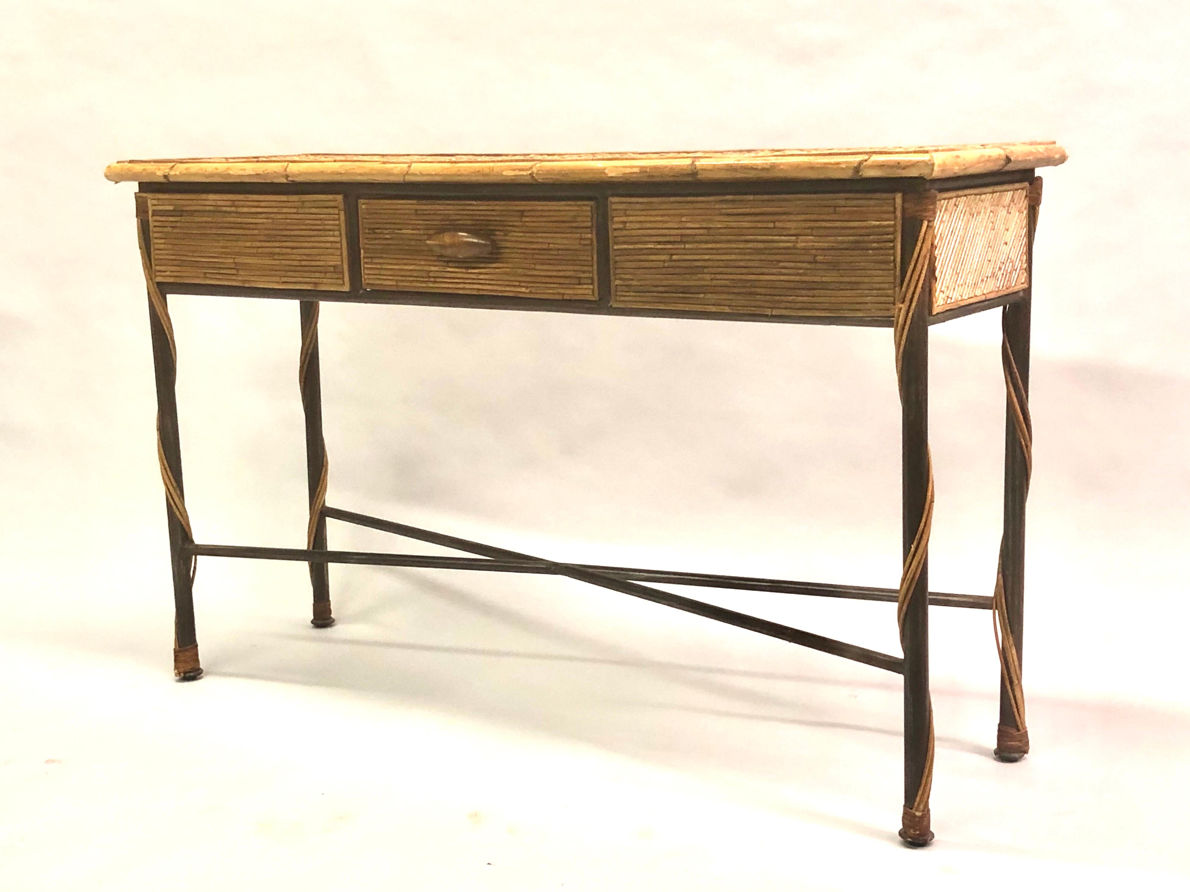 Console / table de canapé moderne néoclassique française en fer forgé et rotin avec tiroir central. 

La pièce présente un cadre en X classique en fer forgé, un tiroir et des tabliers en rotin incrusté et un plateau au délicat motif hachuré. 

 