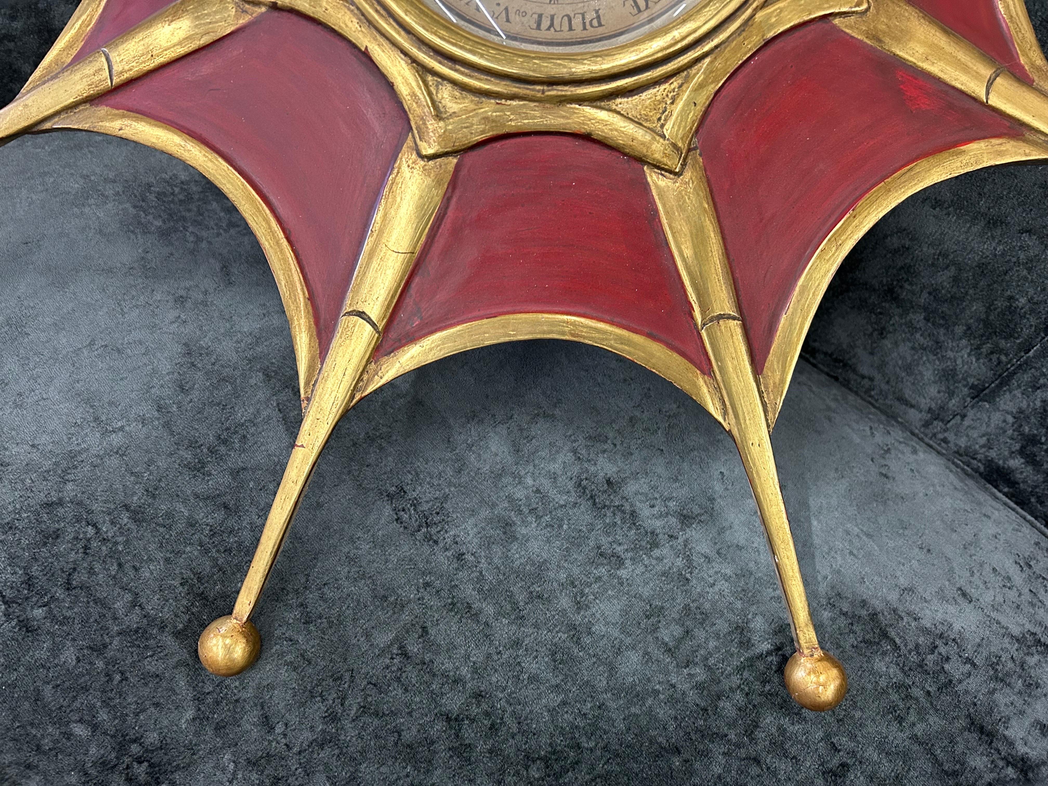 Baromètre moderne en bois peint et doré.
Ce baromètre en forme d'étoile du milieu du siècle dernier est exécuté dans une belle nuance de rouge avec des dorures.
les accents en bois.
Ce baromètre polyvalent serait tout aussi à l'aise dans un décor du