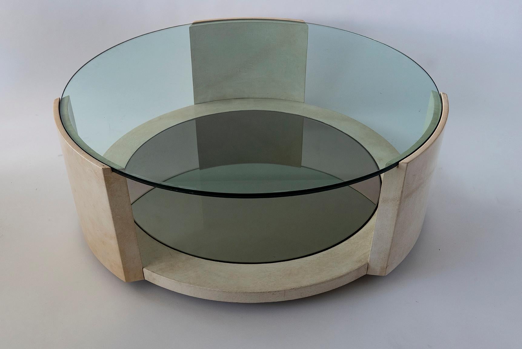 The circular glass top above a parchment base the lower tier with smoke glass insert.