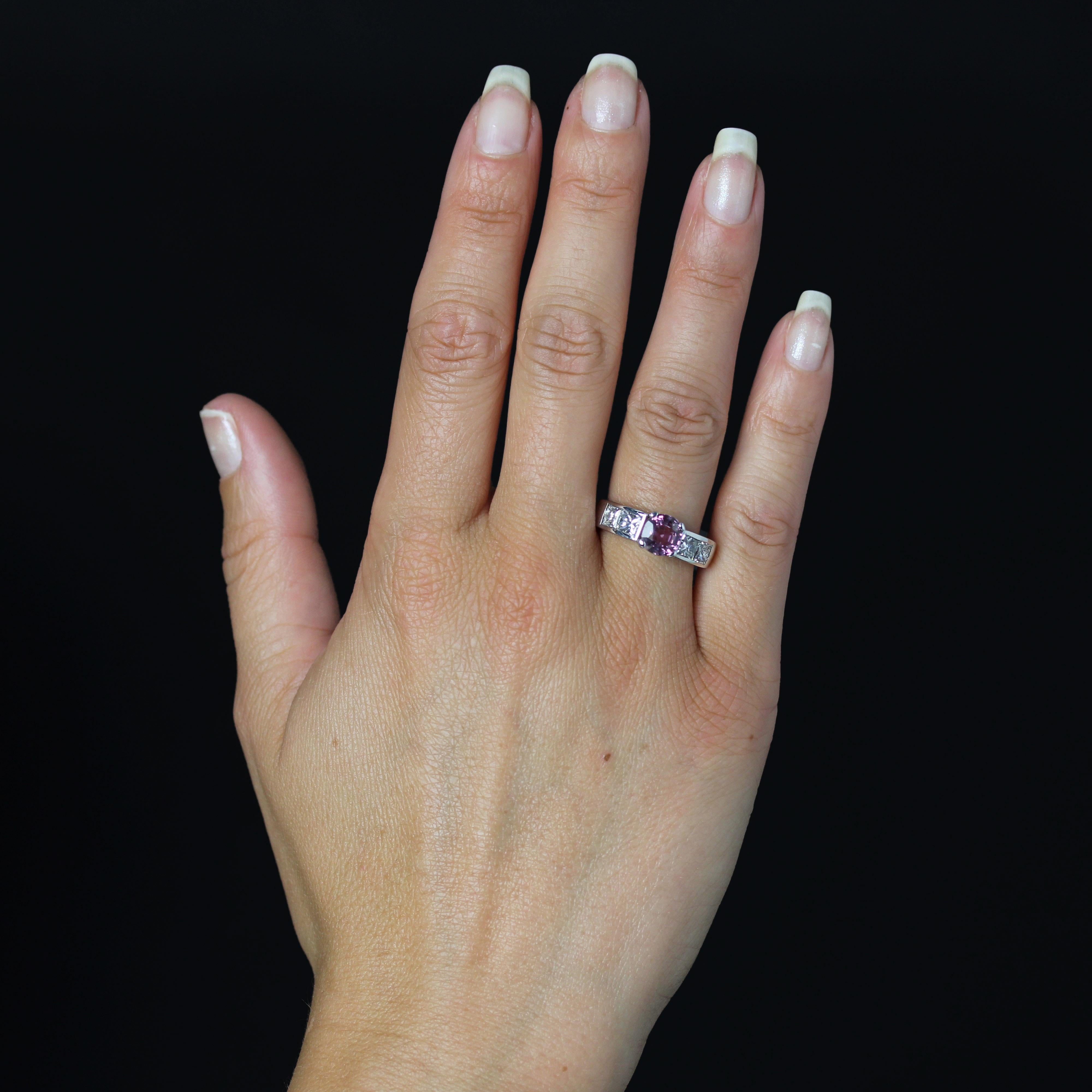 Bague en or blanc 18 carats, poinçon tête d'aigle.
Cette bague contemporaine présente un large anneau aux lignes géométriques, orné de part et d'autre de la tête d'un serti rail avec 2x2 diamants de taille princesse. Au centre, un saphir rose est
