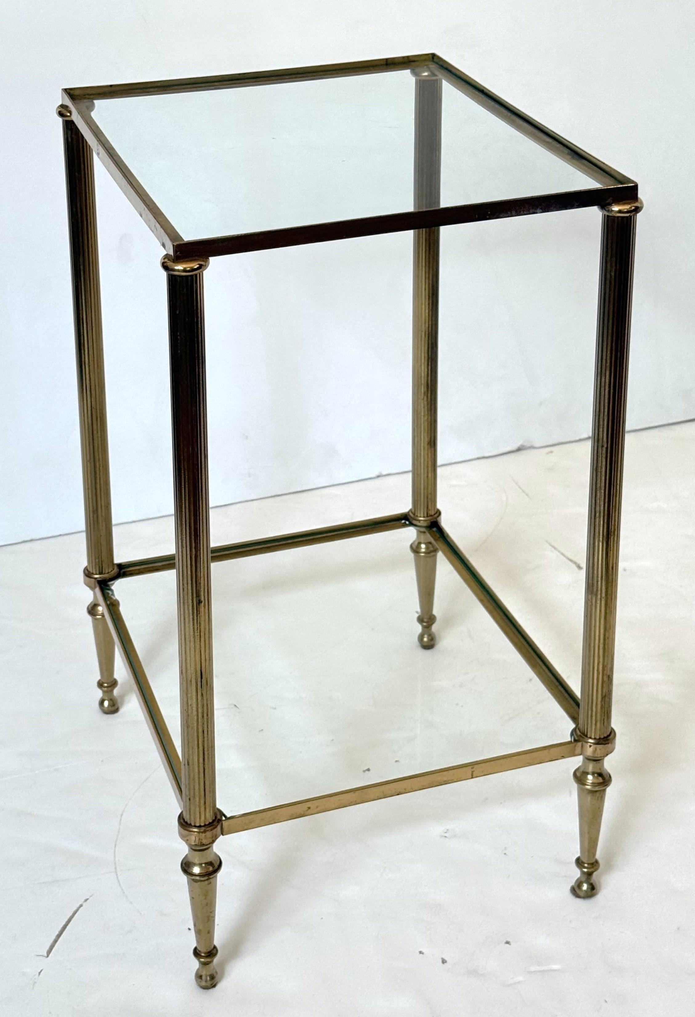 Una coppia di raffinati tavolini moderni francesi - ogni tavolino ha una struttura in ottone rettangolare a due livelli con piano e pannelli inferiori in vetro rettangolare incastonati, e poggia su gambe affusolate e arcuate.

Misure:

H: 22 3/8