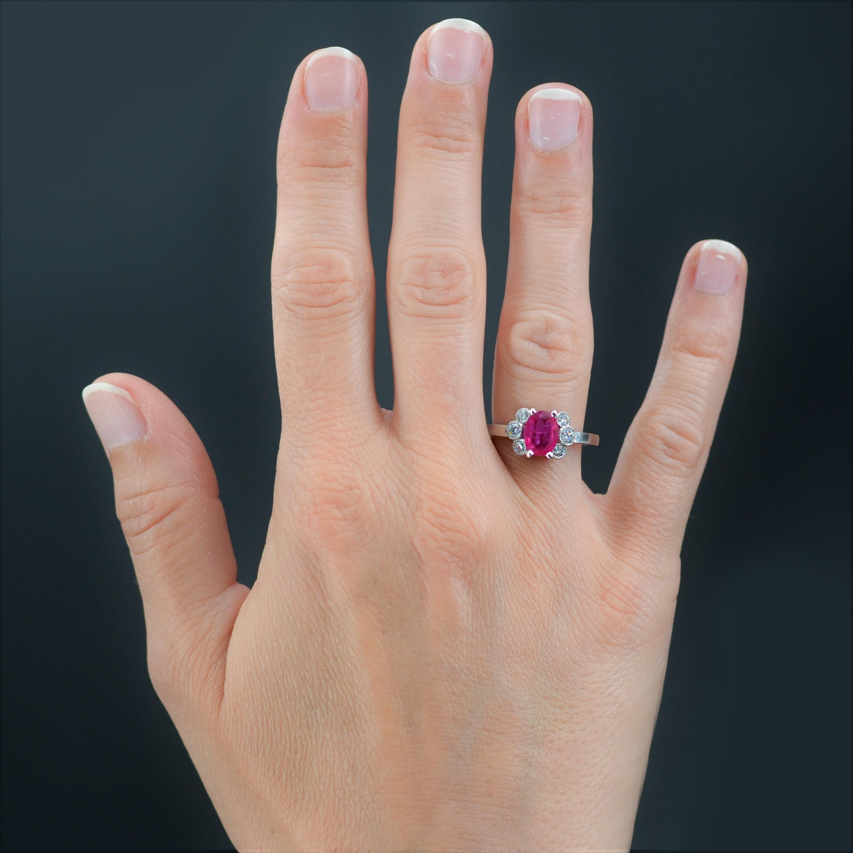 Ring in platinum, dog head hallmark.
Charm ring, it is set with 4 claws of an oval ruby supported like a flower by 3 modern brilliant-cut diamonds in millegrain setting on both sides. 
Total weight of the ruby : about 1.06 carat, total weight of the