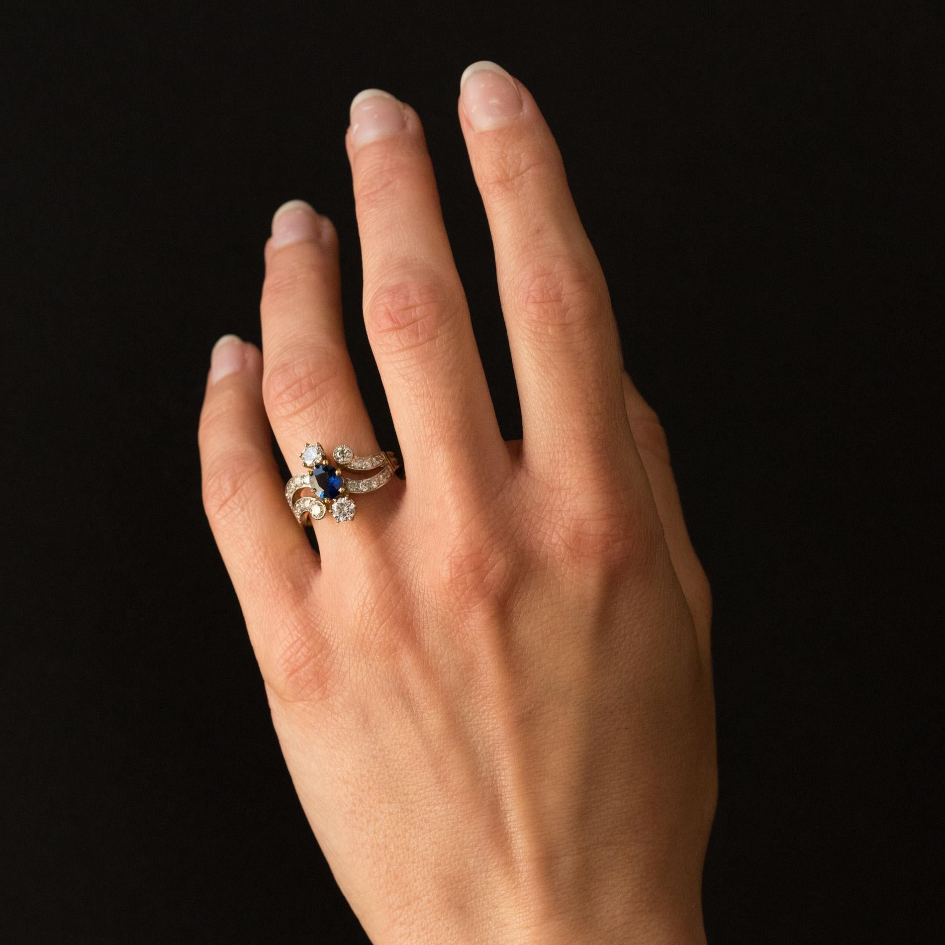 Ring in 18 karats yellow gold, eagle's head hallmark, and platinum, dog's head hallmark.
Lovely and feminine antique style ring, it is claws set on its top of an oval sapphire, of 2 brilliant- cut diamonds and 2 other brilliant- cut diamonds set