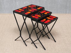 Conjunto francés de tres mesitas apilables de estilo moderno con tableros de azulejos de cerámica rojos y naranjas, década de 1950