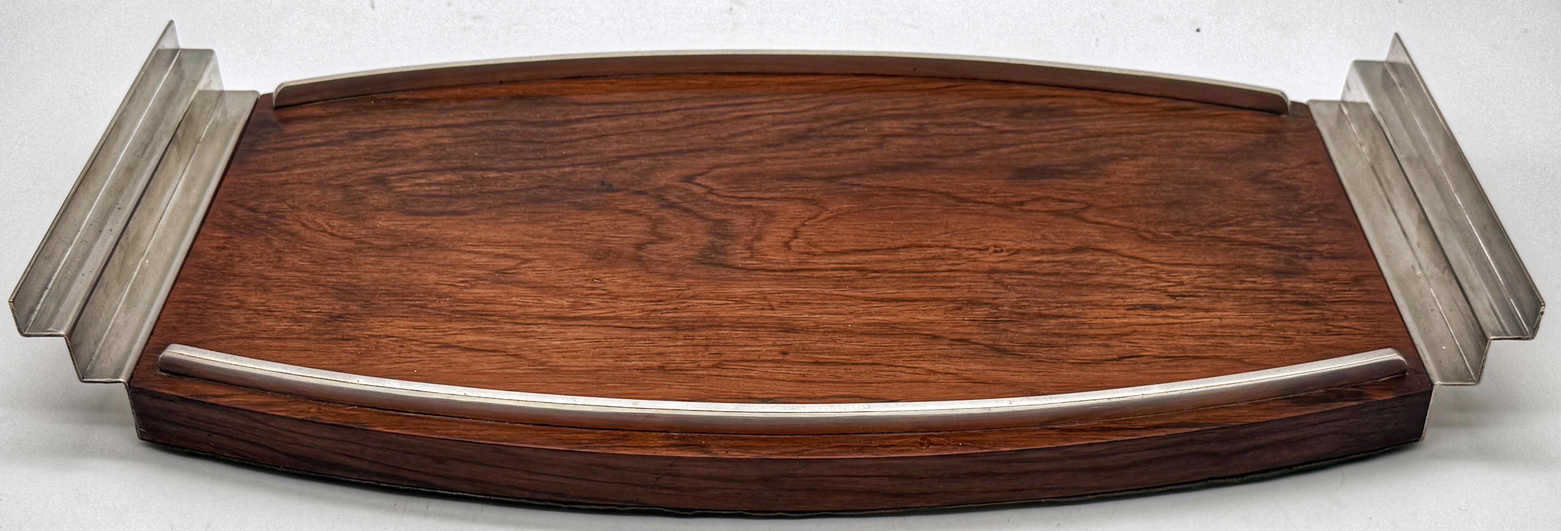 French Modern Silver-Plated and Mahogany Serving Tray

France, Circa 1950s-1960s

Unmarked, Style Influences of the likes of Christofle, Puiforcat, or Jean Després

This French silver-plated and mahogany tray dates from the 1950s–1960s, reflecting