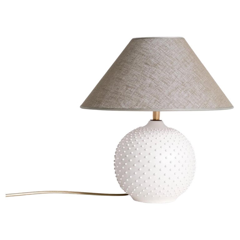 This elegant table lamp was produced in France in the 1950s. The spiked texture of the white ceramic sphere gives the lamp a refined appearance. New custom shade with linen texture in a green/gray color which contrasts nicely with the white base.