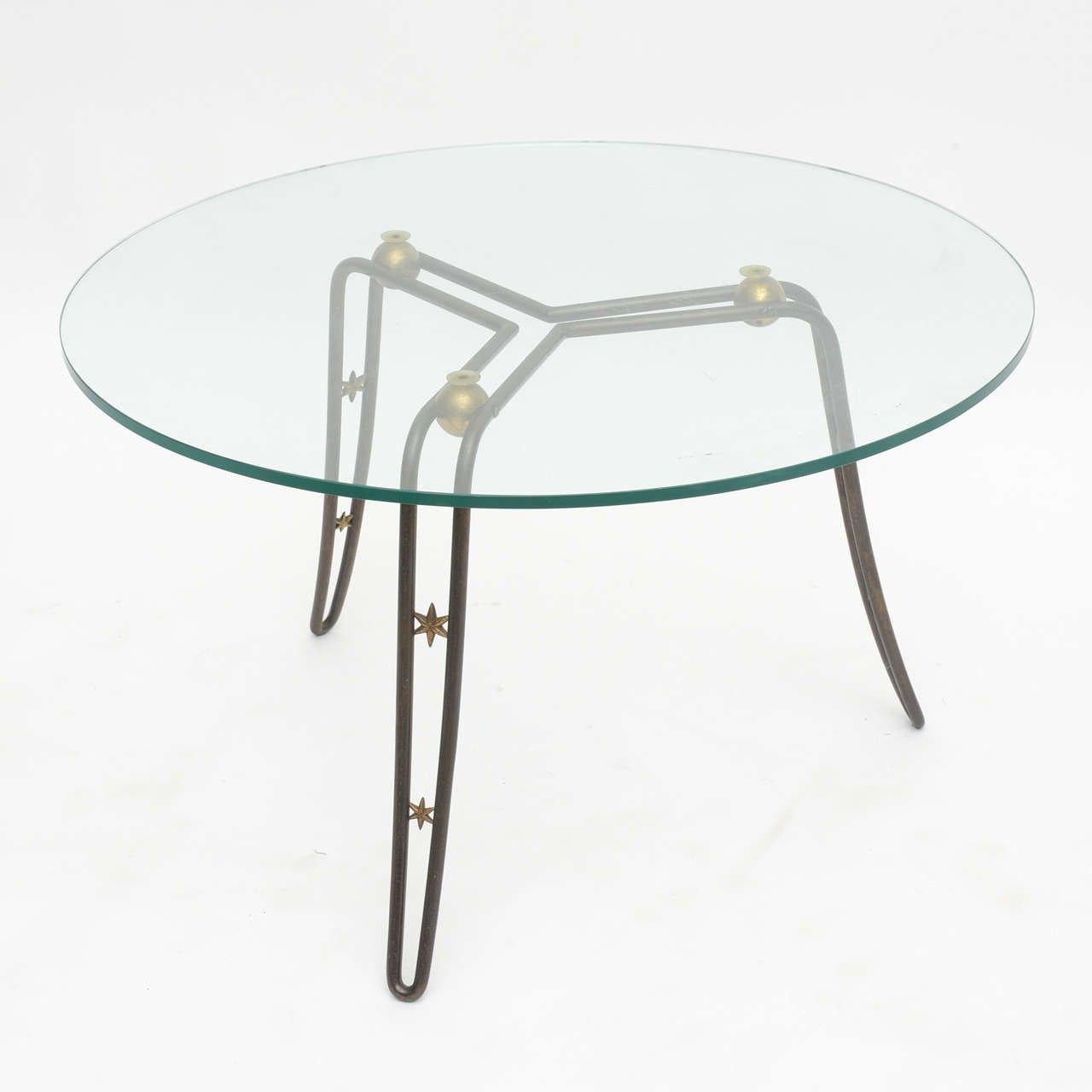 The circular top above a steel frame with three legs accented by brass stars and spheres-can accommodate glass top up to 42