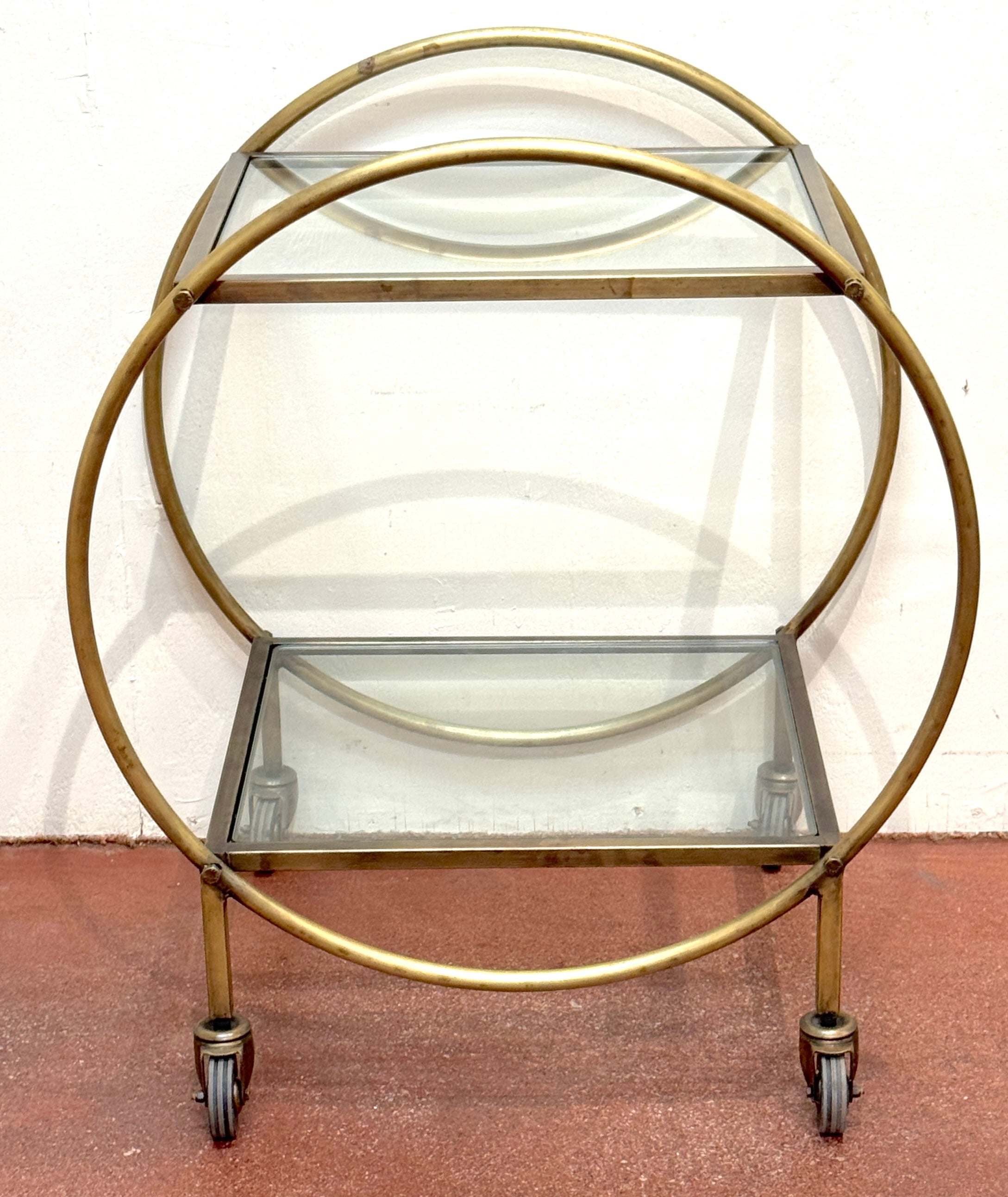 Chariot de bar sphérique à deux niveaux en métal doré patiné et verre, CIRCA, années 1970

Exemple frappant du design moderniste français, ce sculptural chariot de bar à deux niveaux présente un cadre circulaire en métal doré patiné qui renferme