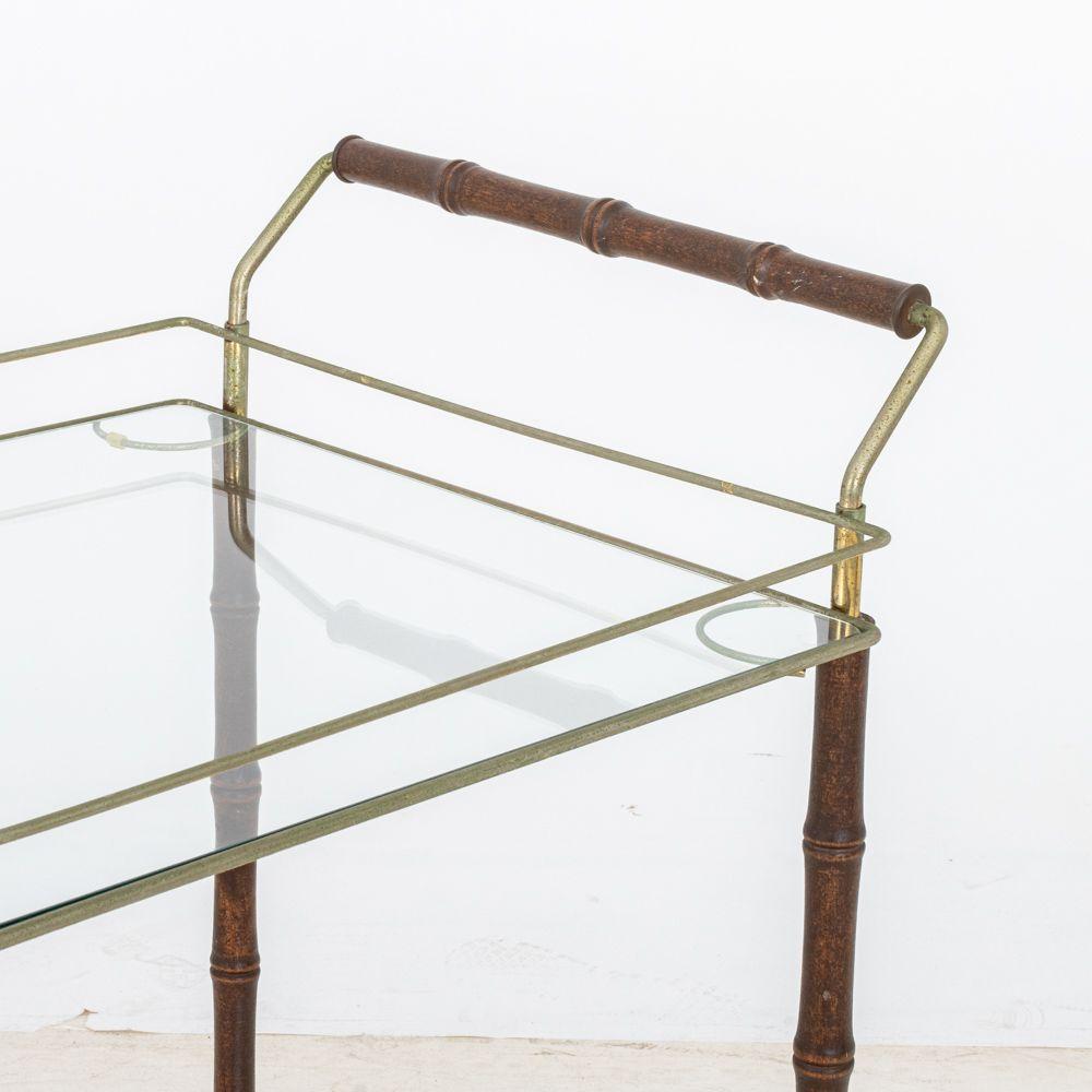Carrello da bar moderno francese a due piani in ottone e noce, con due piani in vetro sopra quattro ruote rivestite in ottone, le ruote sono marcate 
