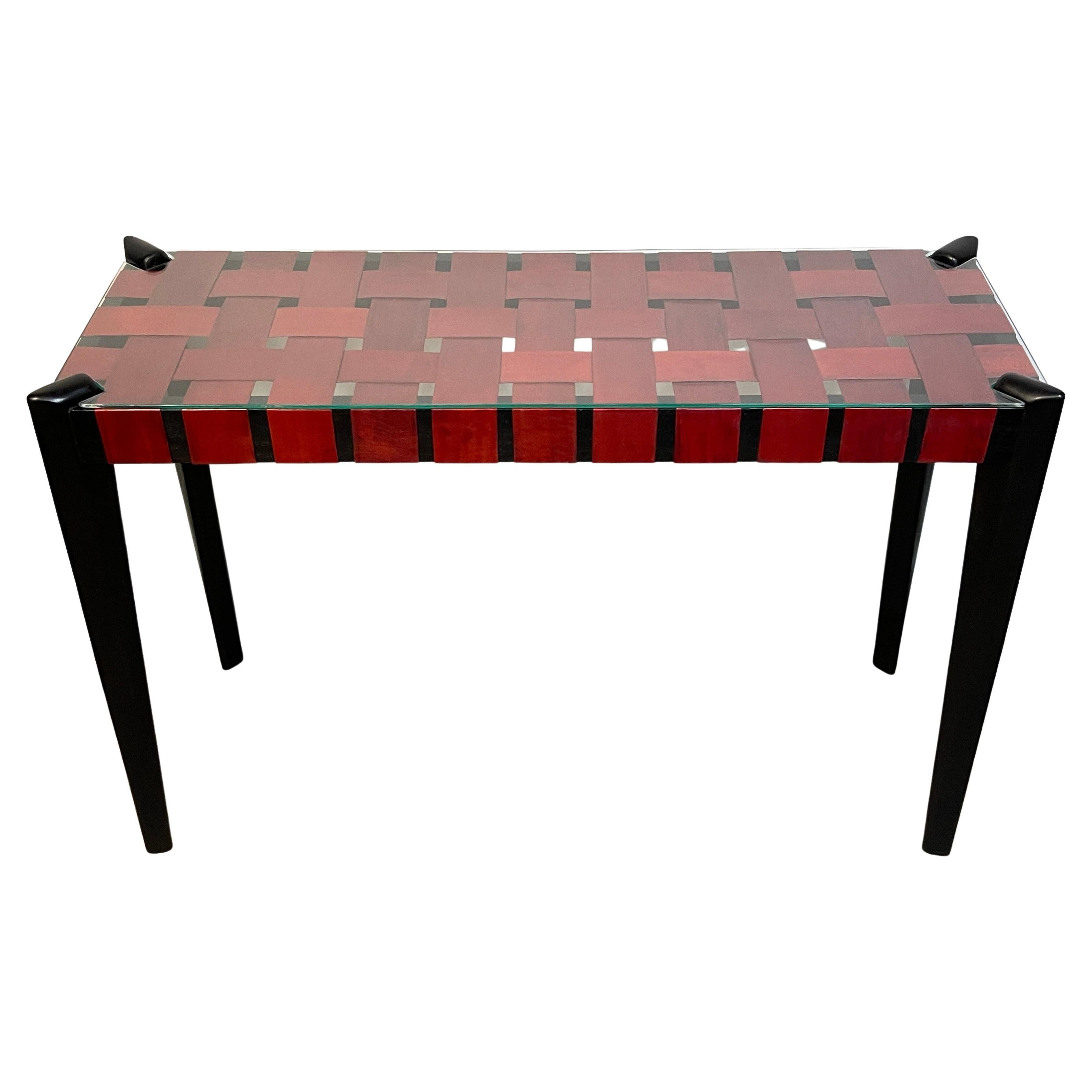 French modern woven red leather strap console table
Sleek, well designed with four ebonized tapering angled legs, supporting the top with 3-Inch wide woven red leather straps, with glass top.
The console measures 48-Inches wide x 17-inches deep x
