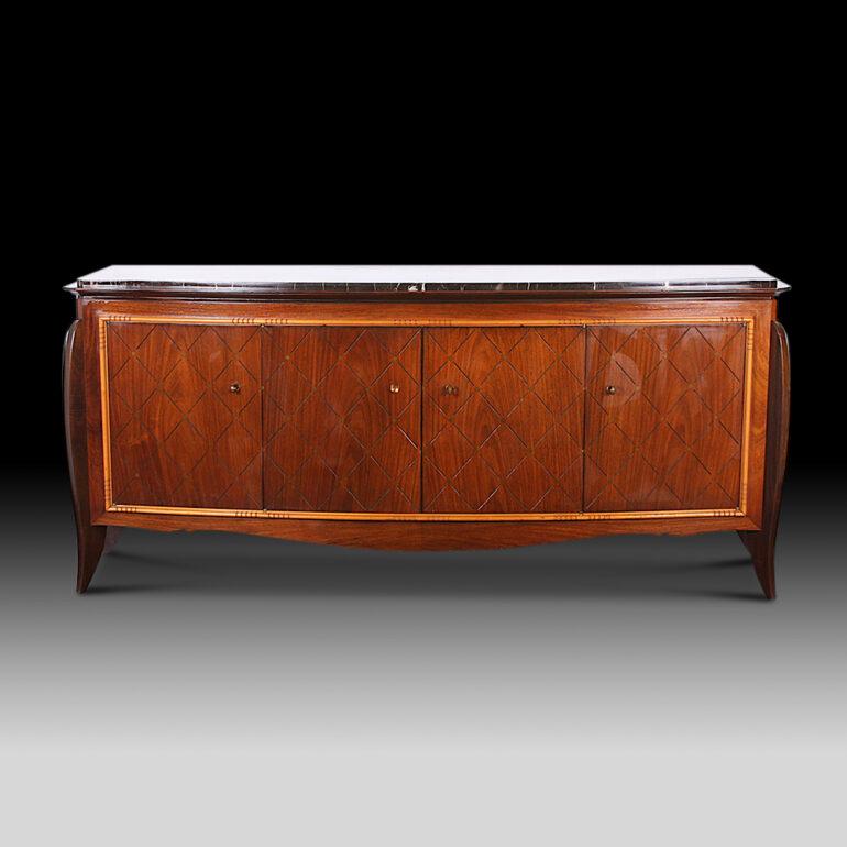 An elegant French Moderne buffet or credenza in macassar ebony, the curved front fitted with four doors with geometric incised diamond pattern and framed with pale beechwood trim. Elegant curved legs and the original marble top. C. 1940 – 50.