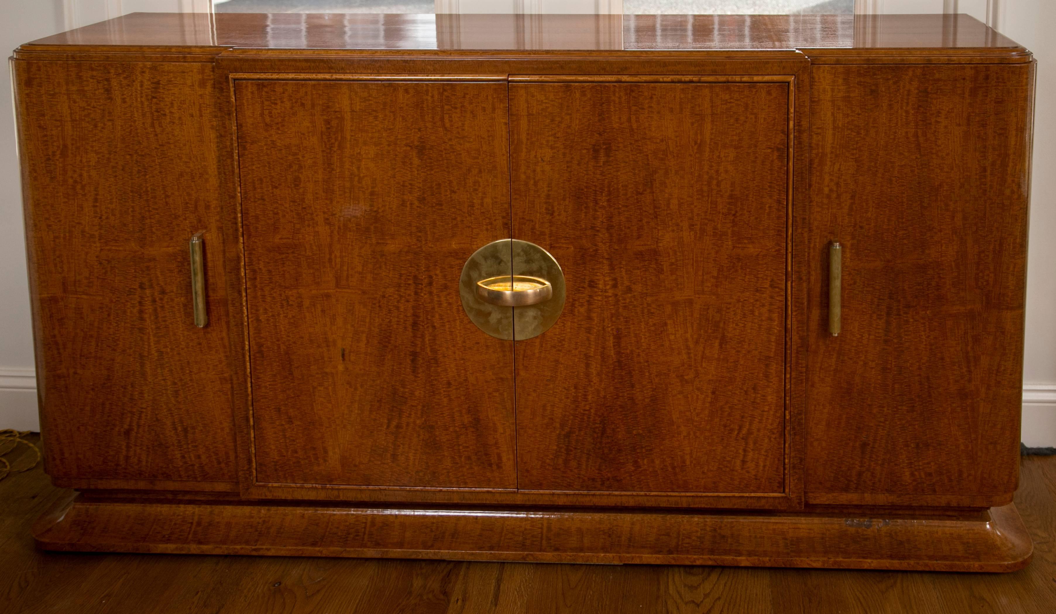 Beautiful French art moderne sideboard in quartered blonde amboyna veneer comprised of rounded corners and four doors opening to mahogany interior outfitted with shelves, adorned with solid brass bar pulls
Origin: French
Dating: circa