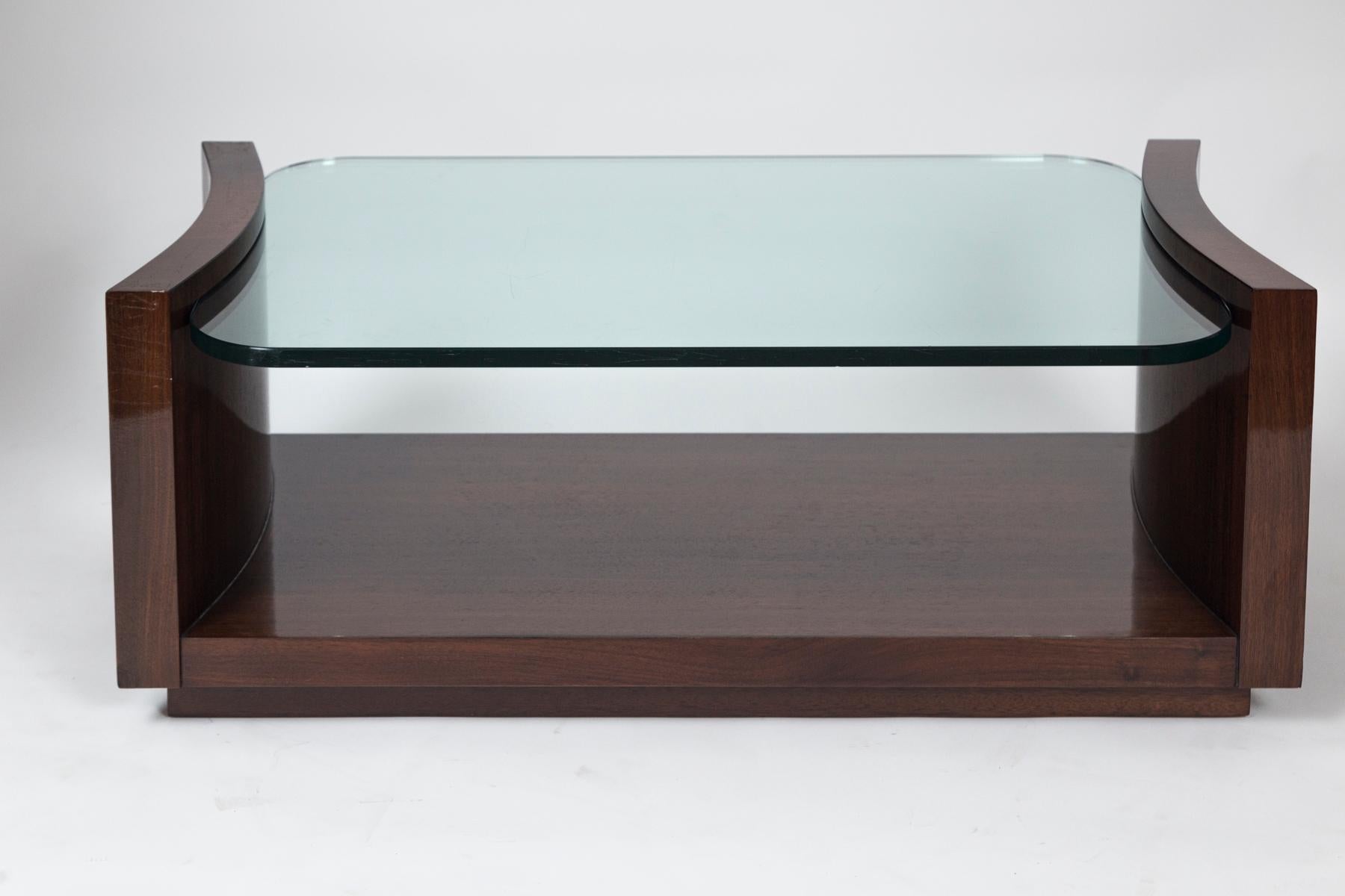 Wonderful sleek incurved low two-tiered table with thick floating glass top suspended by a beautiful rosewood veneer base 

Origin: France

Dating: 1930ca

Dimensions: 46? long, 24? wide, 18? high.