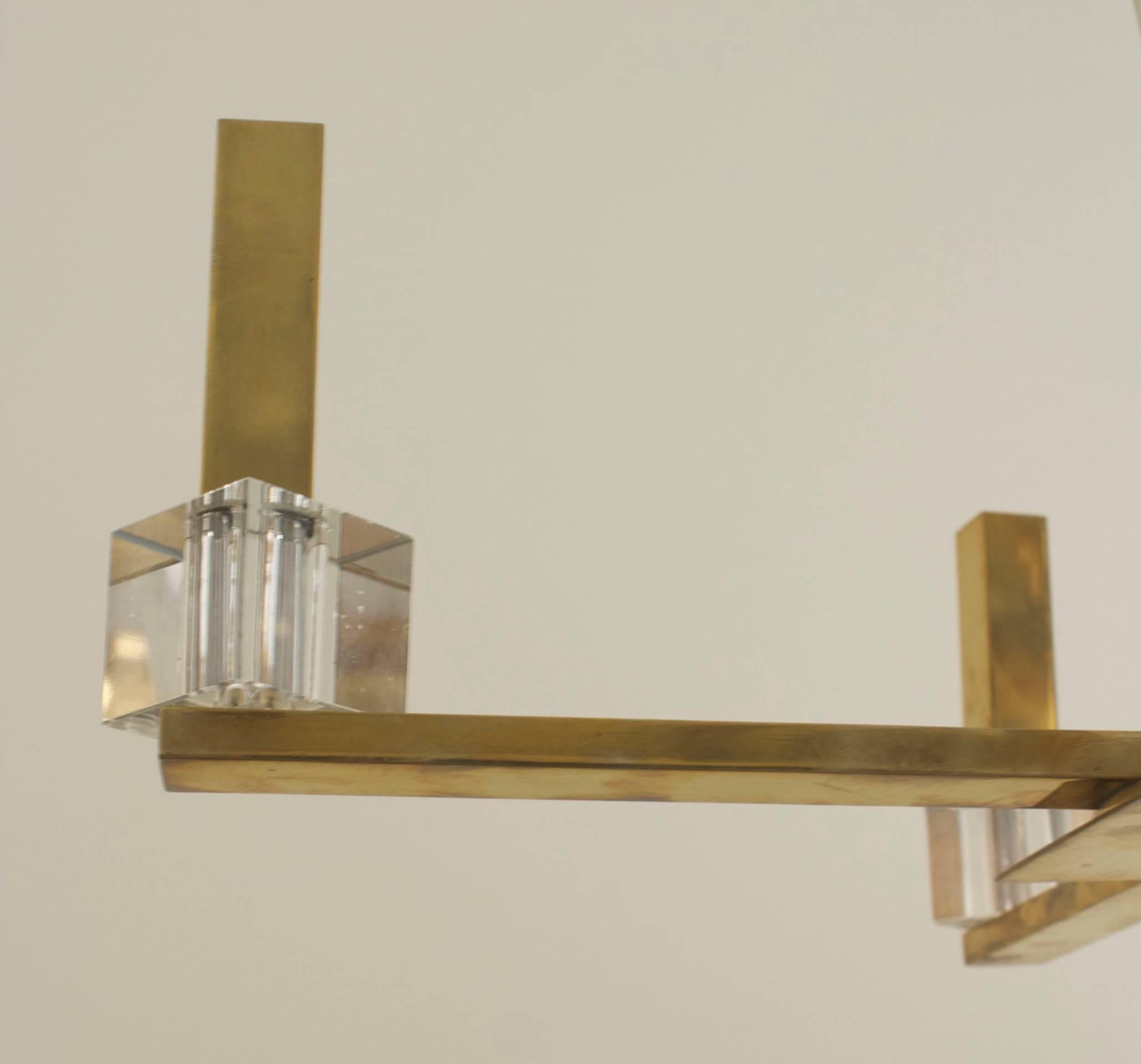 French Modernist (1940s) chandelier with 4 brass & Lucite rectangular arms emanating from a tapered square center shaft and a 3 tier round bottom with a finial.
