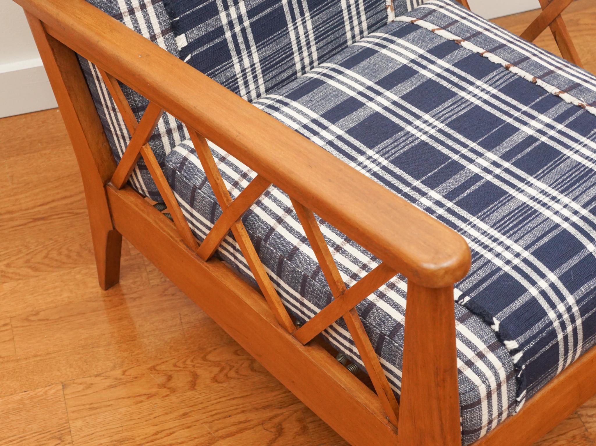 Les lignes épurées et la structure ouverte de ce fauteuil moderniste français avec coussins détachés conviennent parfaitement à une utilisation dans des pièces traditionnelles ou modernes.  Le fauteuil présente une patine vieillie de couleur miel et