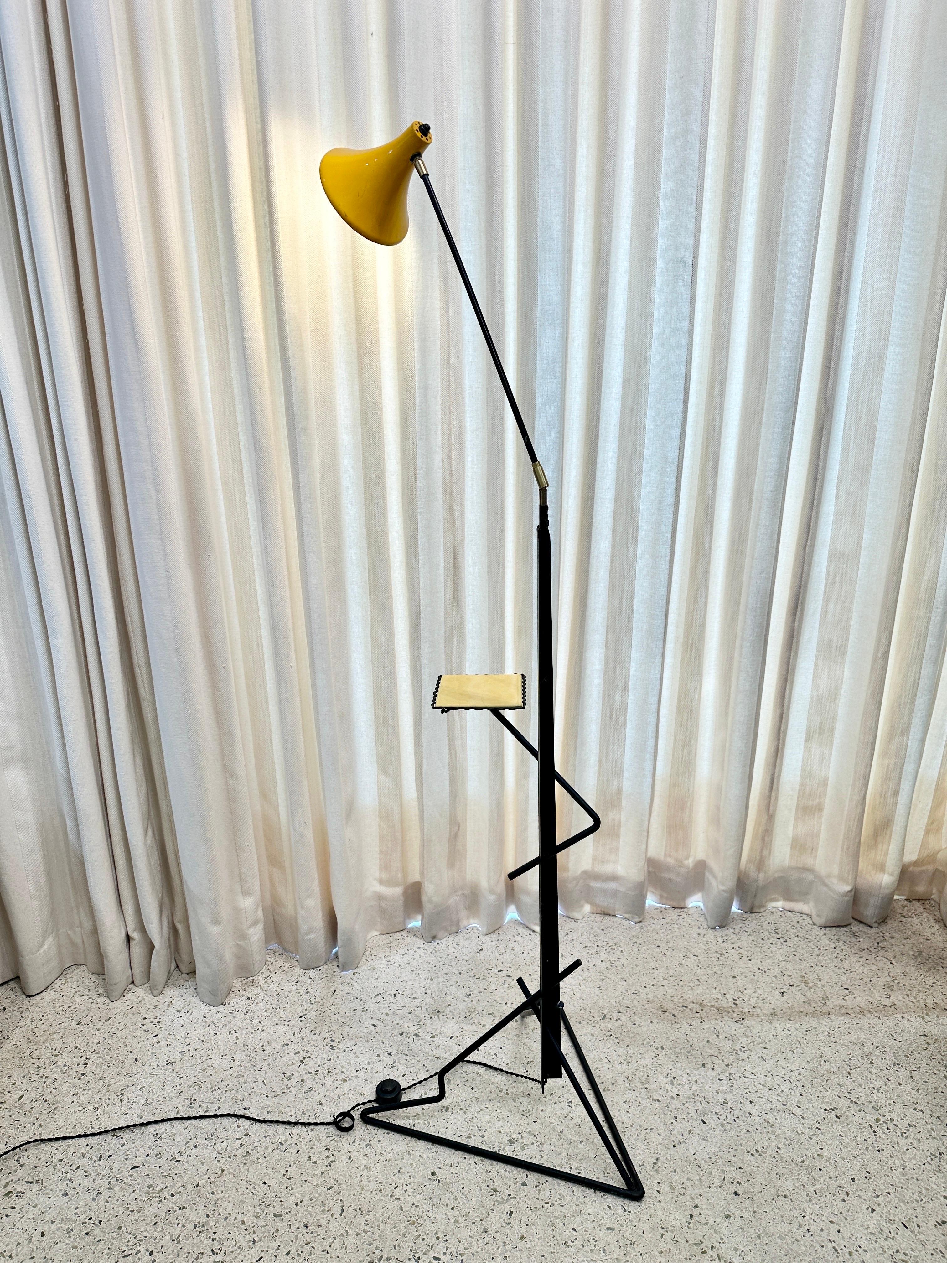 This is such a COOL modernist designed floor lamp with bent metal frame in a very geometric style, which leads to a practical petite table for tea cup or a book.  The articulating arm and shade are adjustable for perfect illumination in your space. 