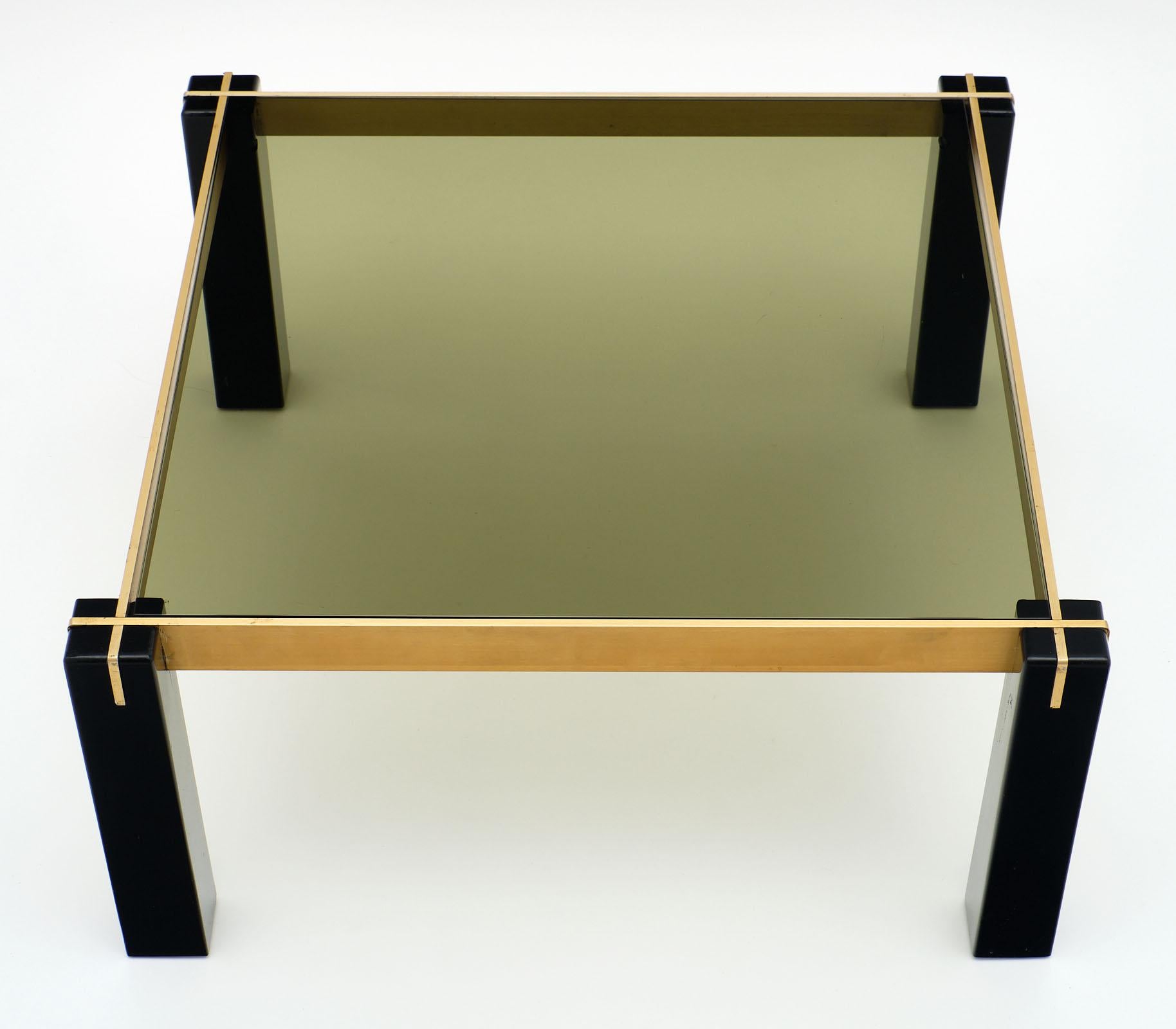French modernist brass and black side tables with vintage square section legs and inserted metal structure holding the smoked glass. We love the strong construction and contrast of the brass and ebonized legs.