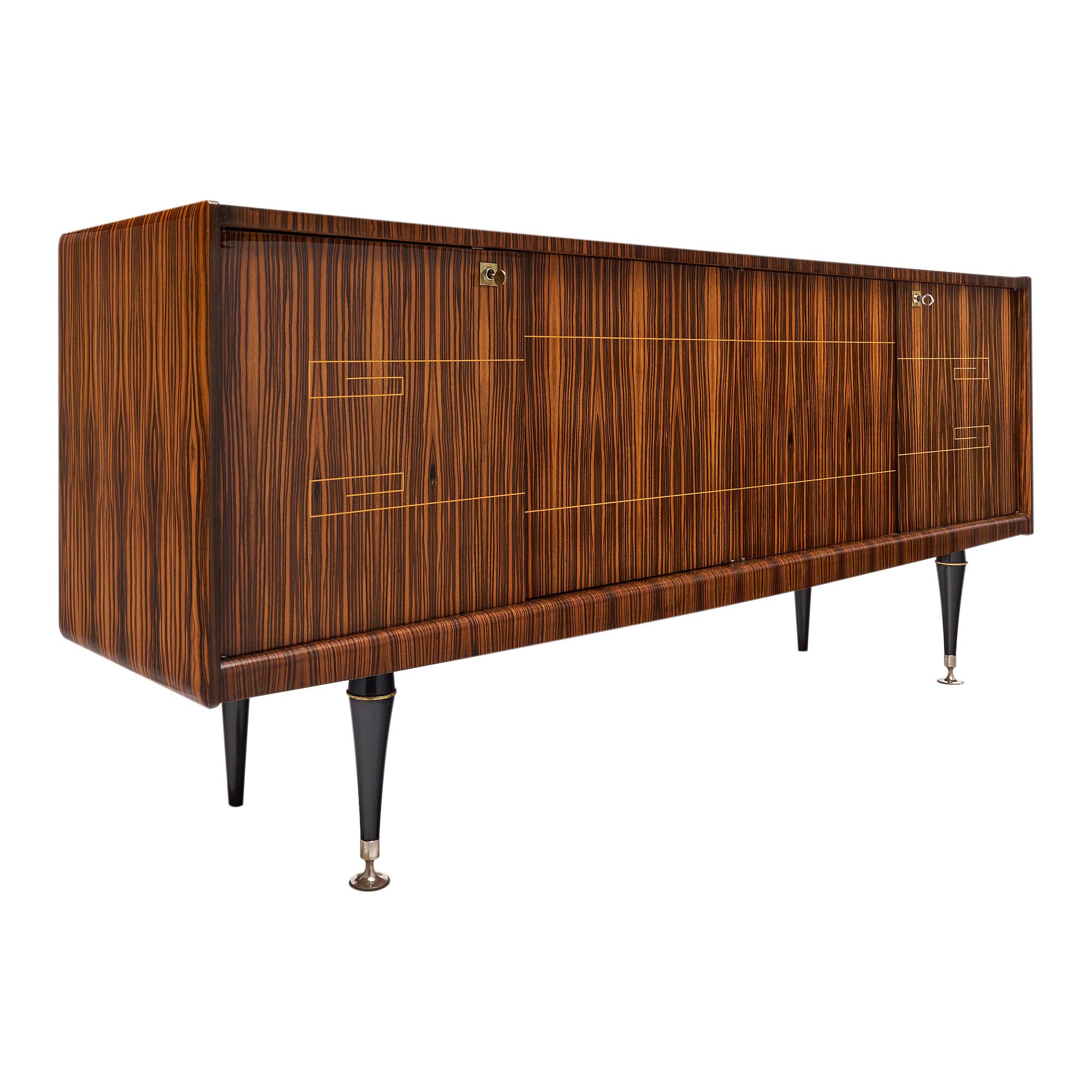 French Buffet, enfilade, from the Modernist era, of ebony of Macassar with a satin wood inlay. Featuring four doors opening to a lemon wood interior offering ample storage, and ebonized tapered legs. This piece is in very nice vintage condition with