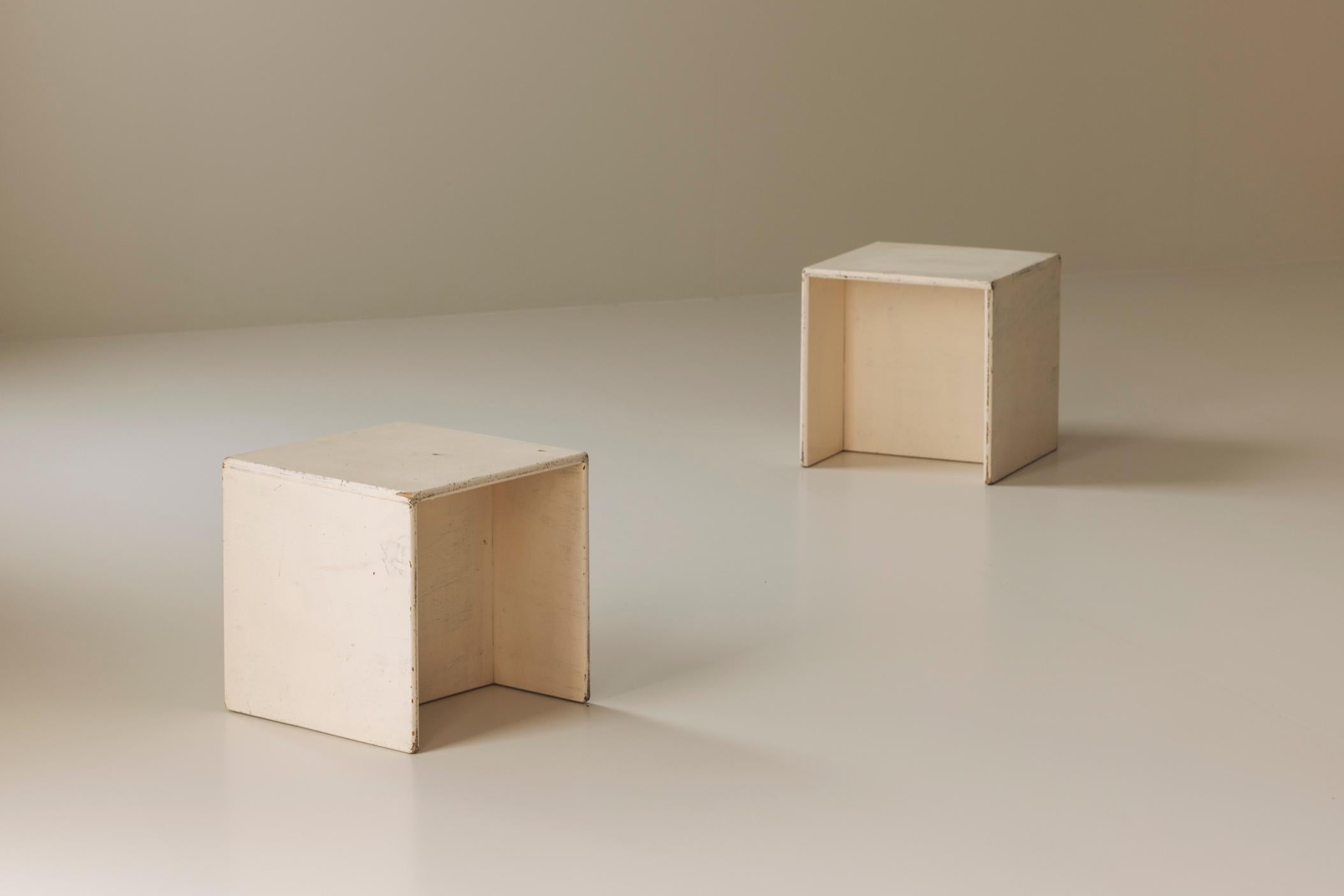 Sourced in France and dating from the 1950s, this pair of Modernist open cabinets embodies the refined simplicity of mid-century European design. Finished in a softly worn off-white paint, each piece features a clean, geometric silhouette that
