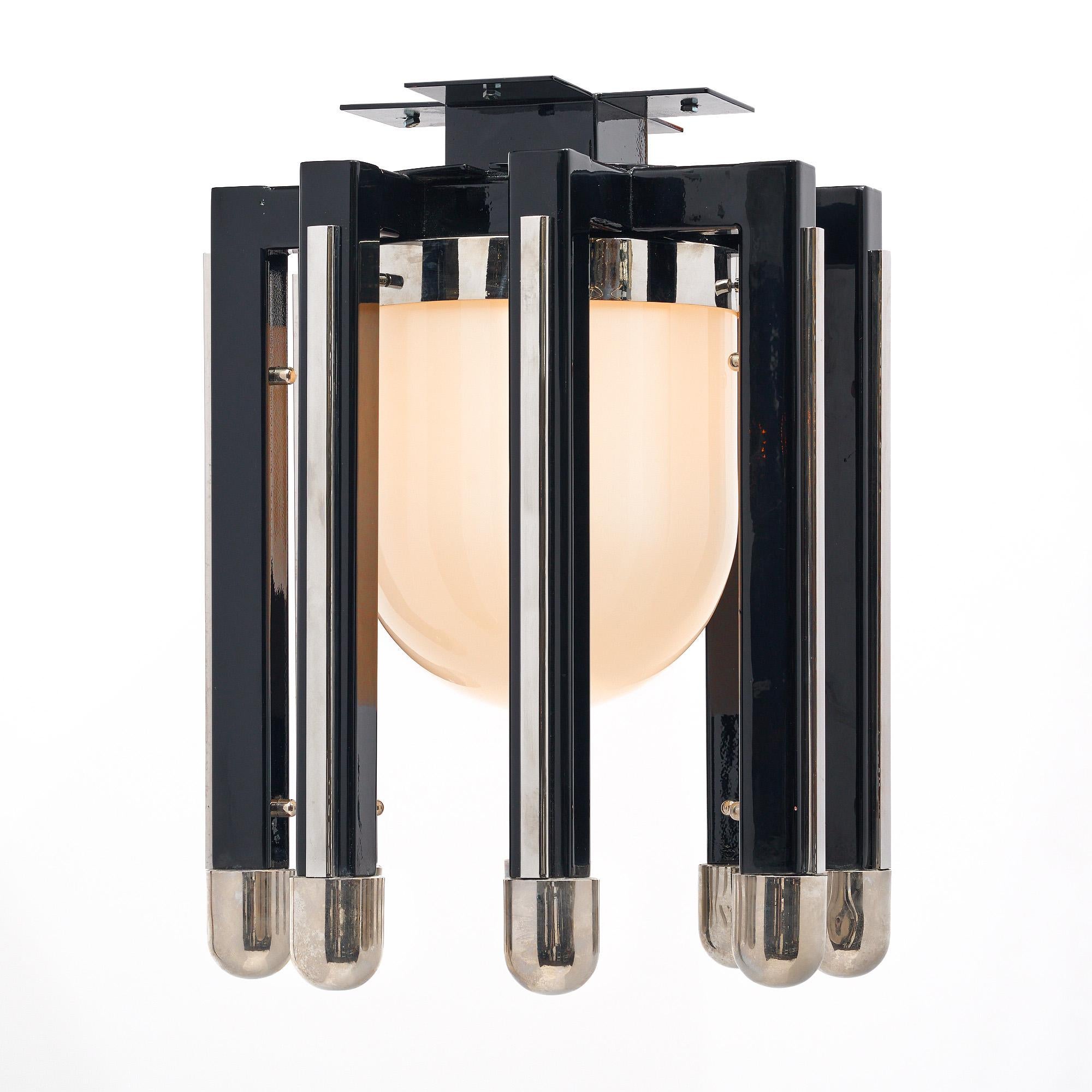 Lantern from the Modernist period in France. This fixture features a central glass globe with eight arms of black lacquered metal. Each is capped with chrome and features chrome detailing throughout. It is in the manner of French designer Philippe