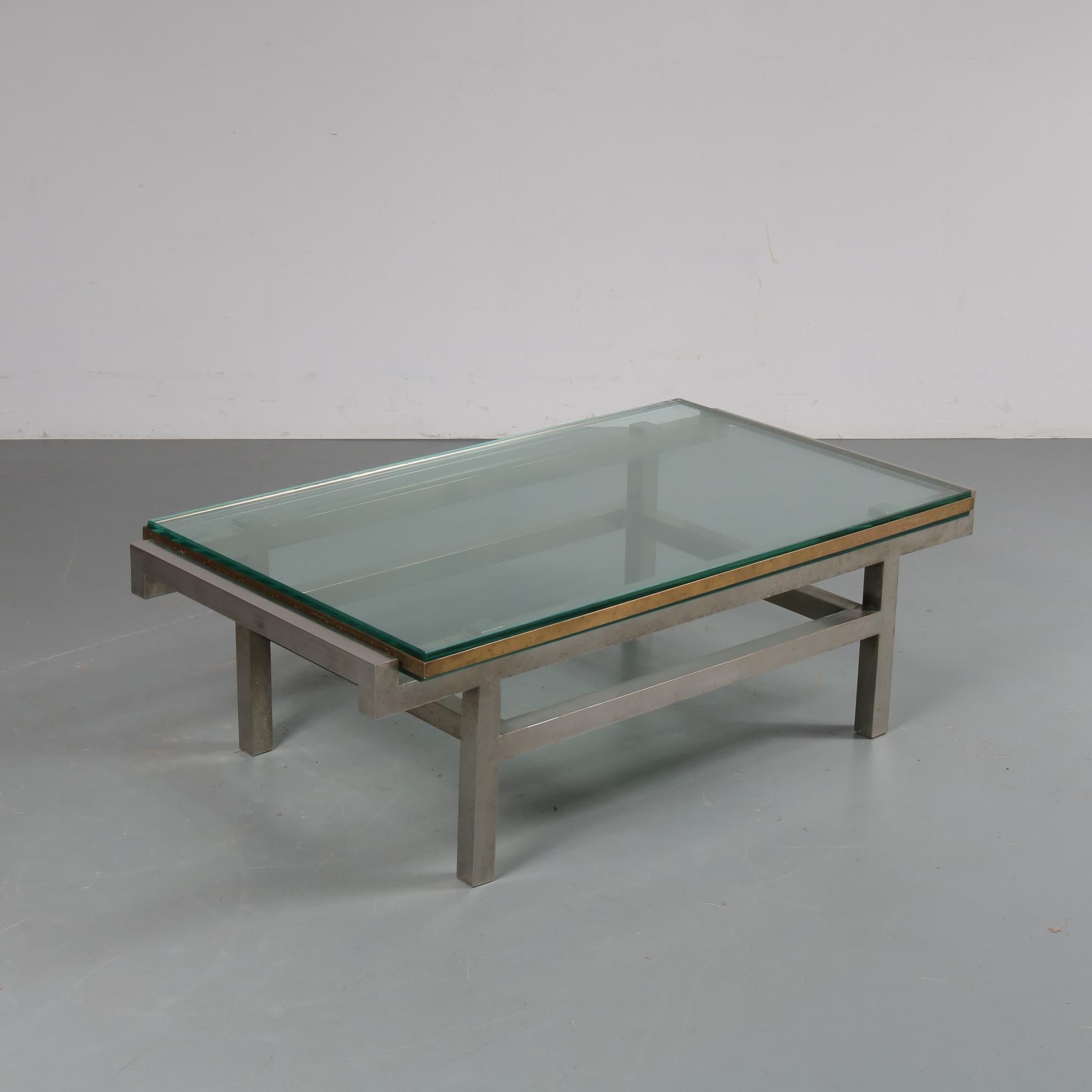A beautiful modernist coffee table manufactured in France, circa 1960.

This very appealing piece is made of high quality grey steel in quare shapes, holding a rectangular clear glass top with golden colored glass edges and a second glass layer