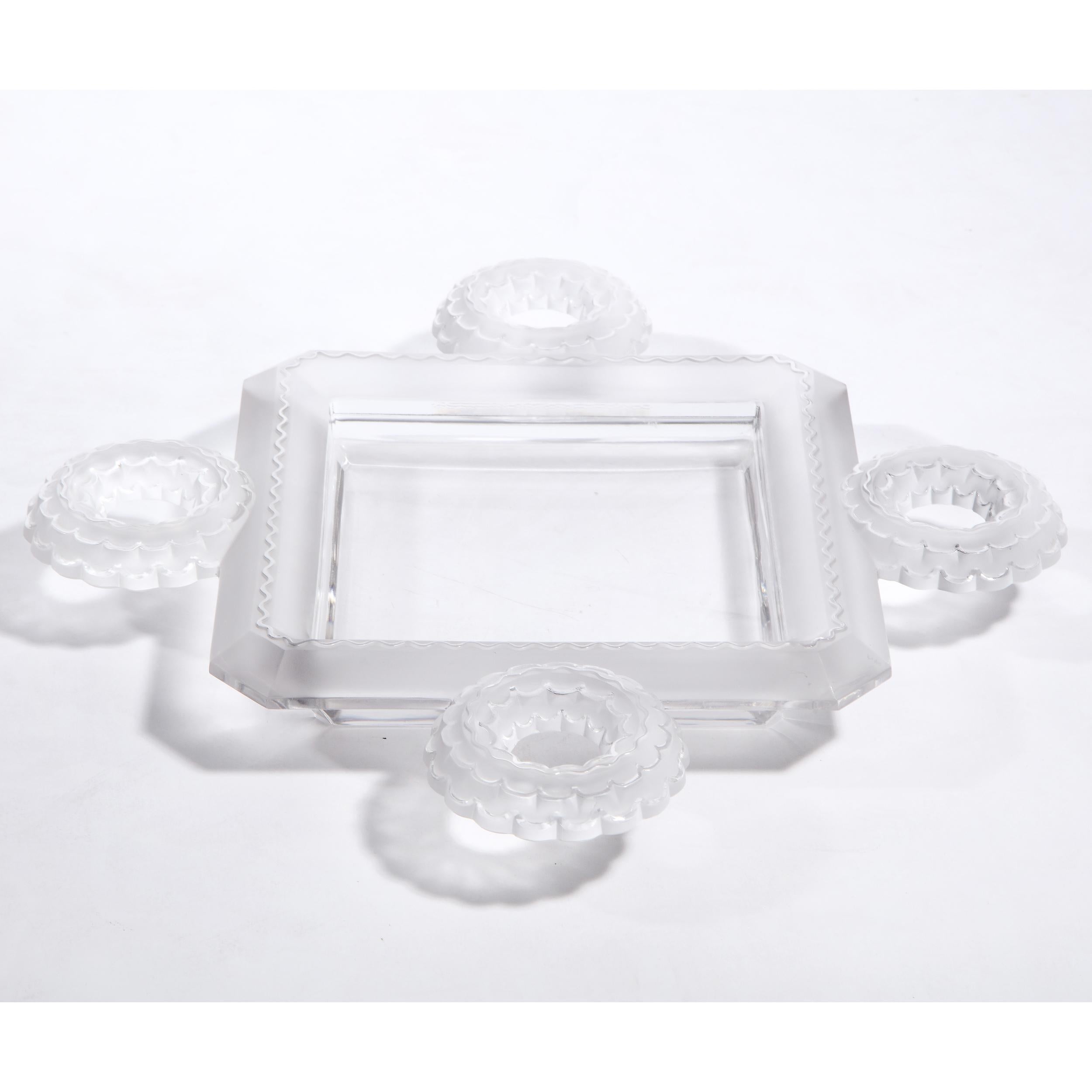 This elegant modernist crystal decorative tray was realized by Lalique- one of the world's most storied and celebrated makers of crystal and luxury goods since 1817 in France- during the latter half of the 20th century. It features a square