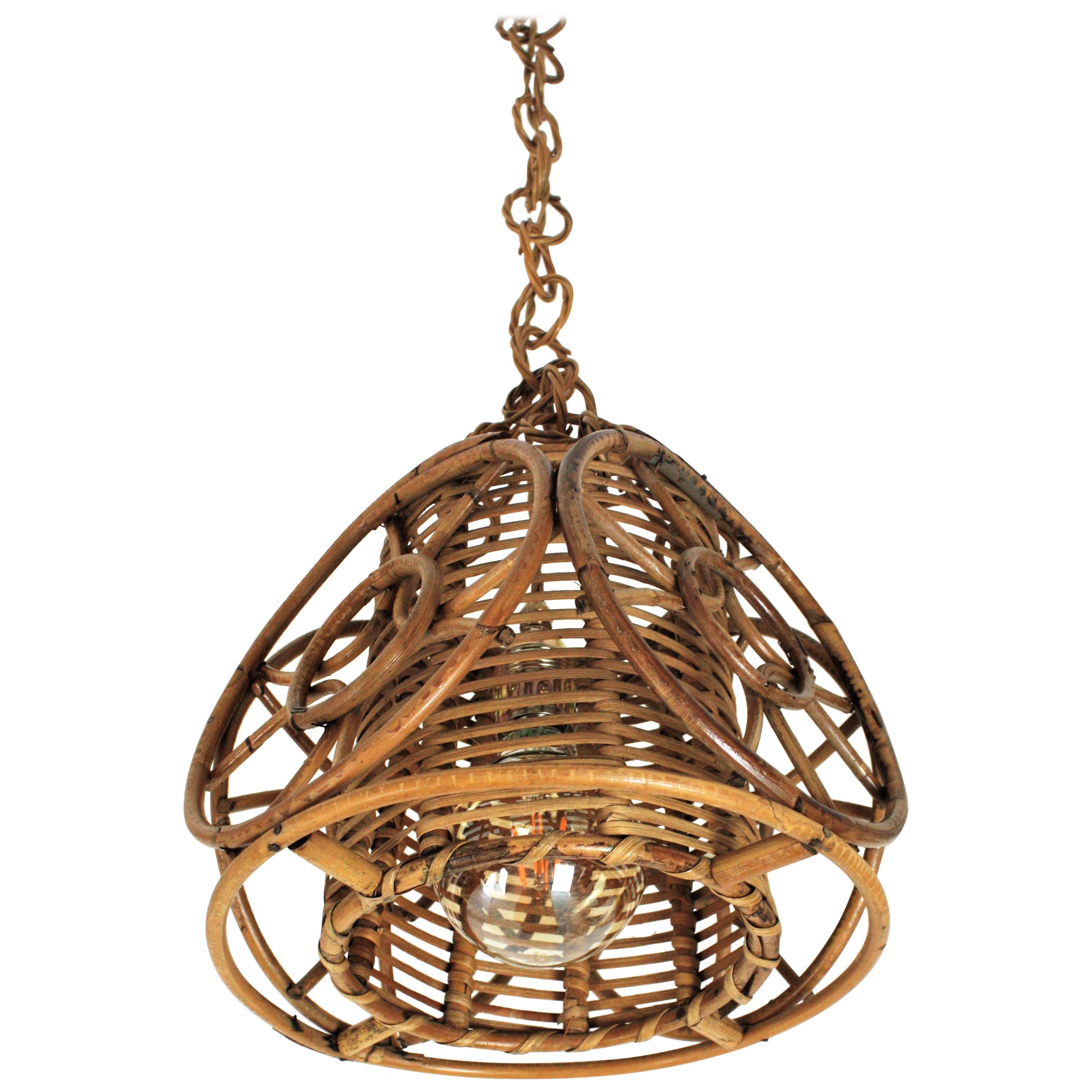 Ciondolo o lanterna in rattan di stile Mid-Century Modern con paralume interno in vimini e decorazioni a cerchi. Francia, anni '50.
Questo ciondolo scultoreo dalla forma conica ha un design insolito con un paralume cilindrico interno in vimini