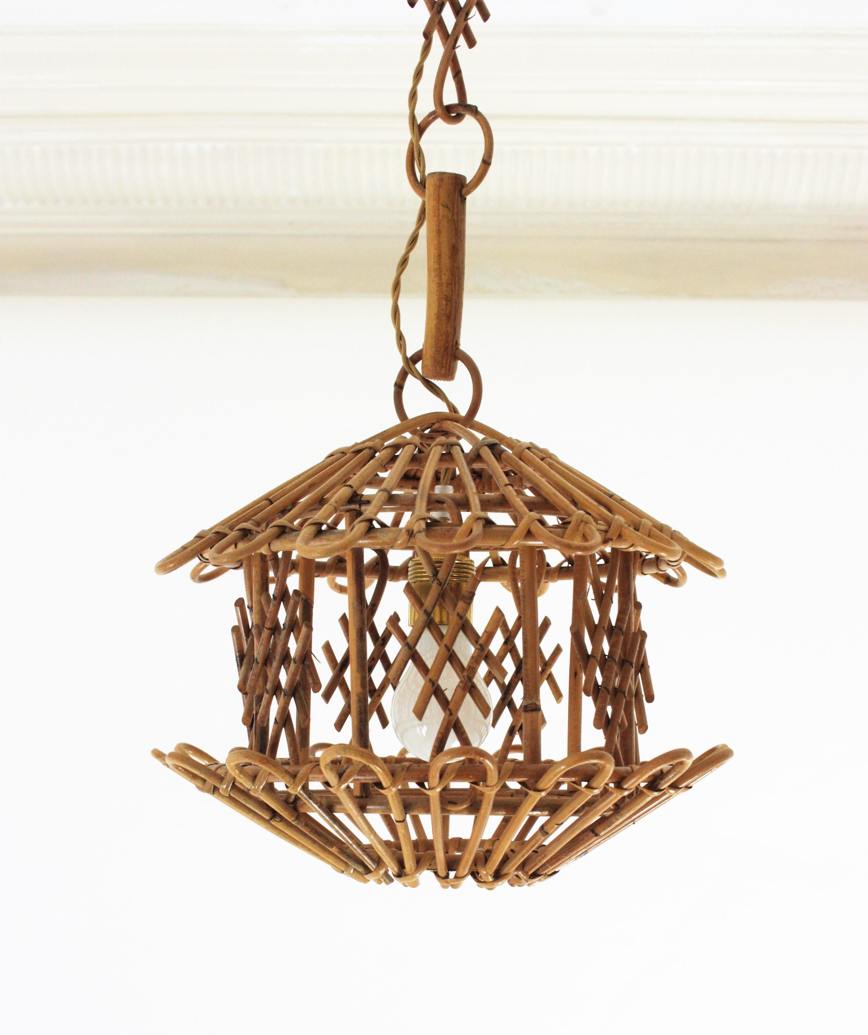 Pagoda suspension lamp, rattan, bamboo, France, 1960s.
Mid-Century Modern bamboo and rattan oriental inspired pagoda shaped pendant or hanging lamp. 
This handcrafted ceiling lamp features a pagoda shaped lantern with chinoiserie decorations. It