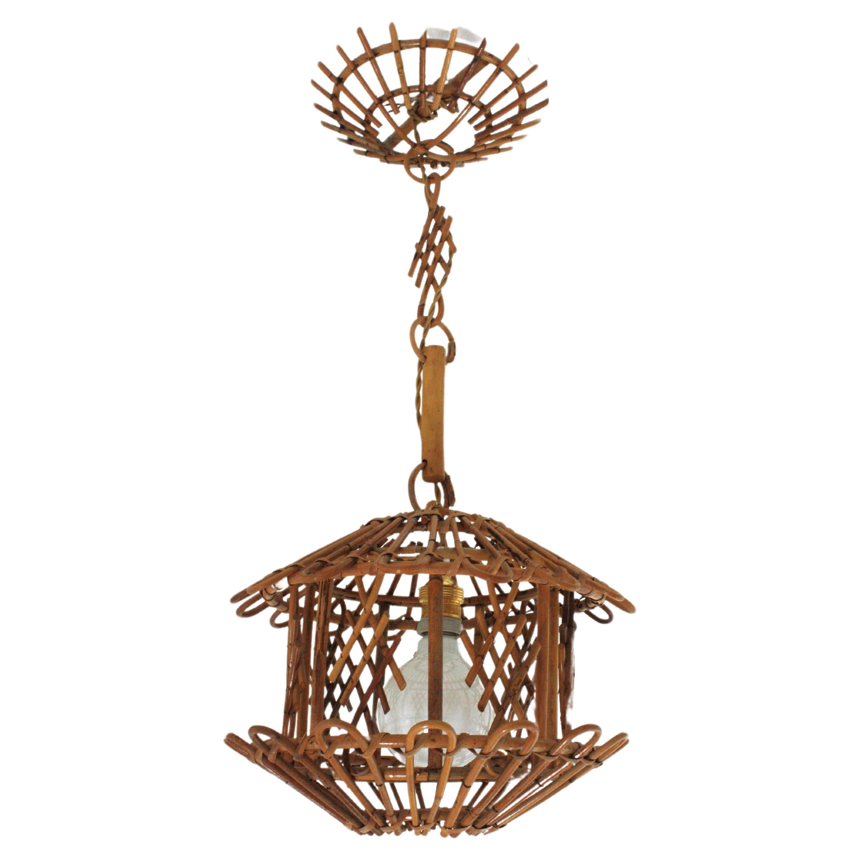 Pagoda suspension lamp, rattan, bamboo, France, 1960s.
Mid-Century Modern bamboo and rattan oriental inspired pagoda shaped pendant or hanging light. 
This handcrafted ceiling lamp features a pagoda shaped lantern with chinoiserie decorations. It