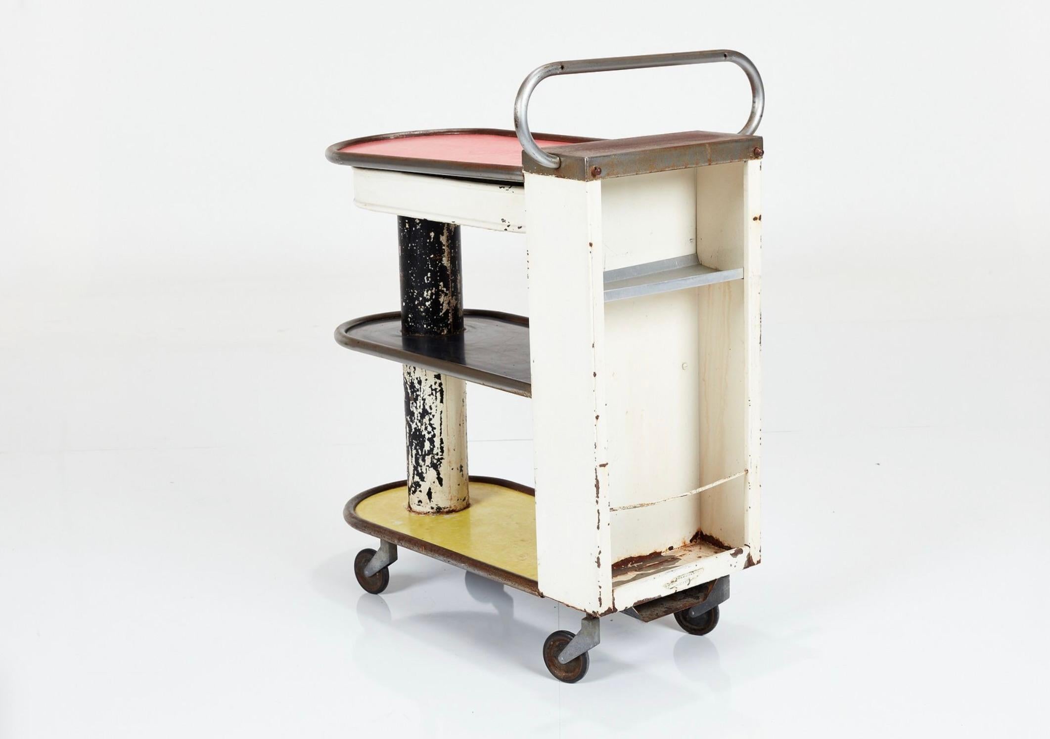 This vintage industrial cart, born in 1950s France, embodies an era of utilitarian elegance. Crafted from robust steel, its sturdy frame and weathered patina tell tales of decades past. Originally a workhorse in factories or warehouses, it now