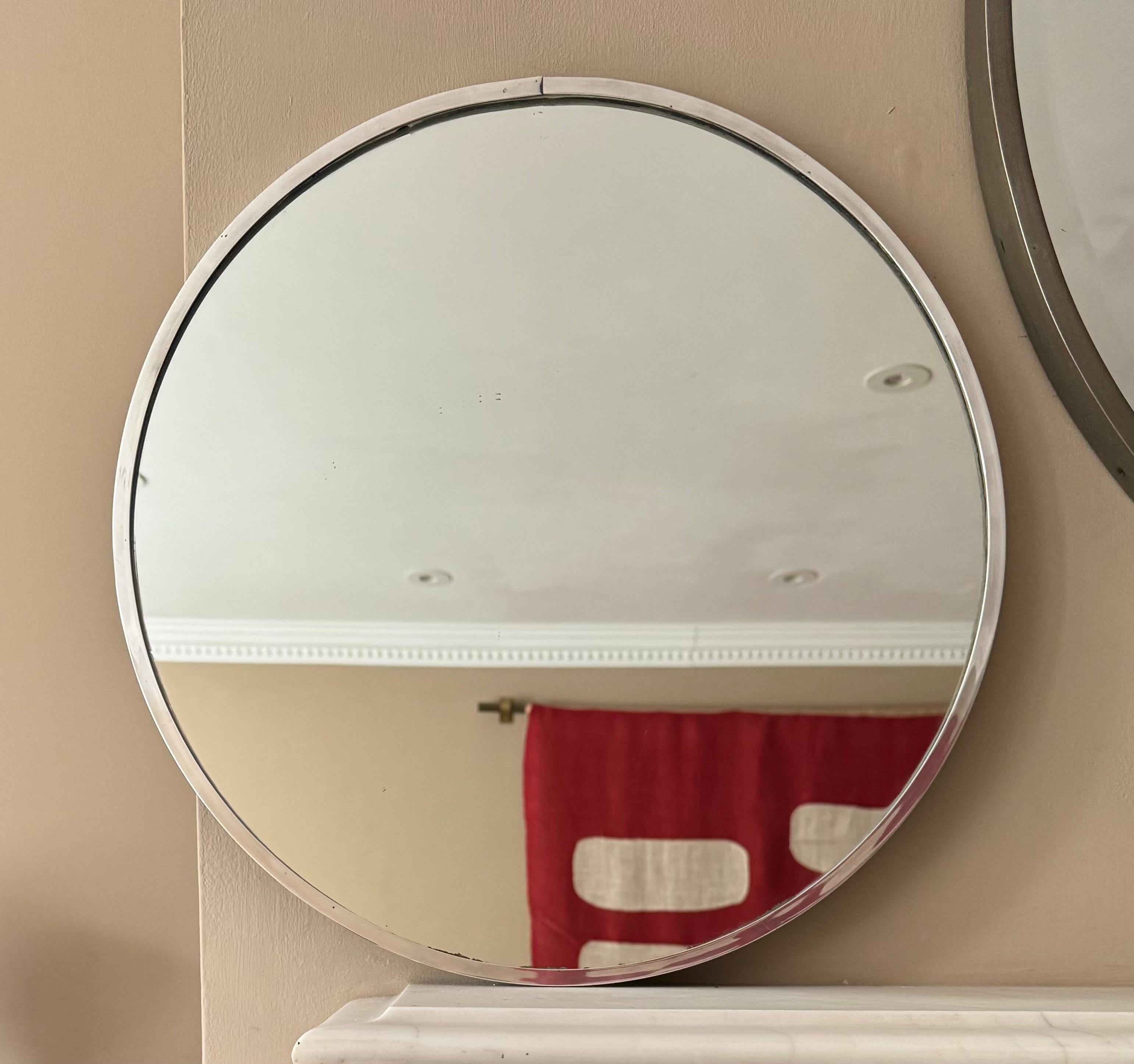 Elegant miroir moderniste encadré de laiton argenté dans le style de Jacques Adnet. 
