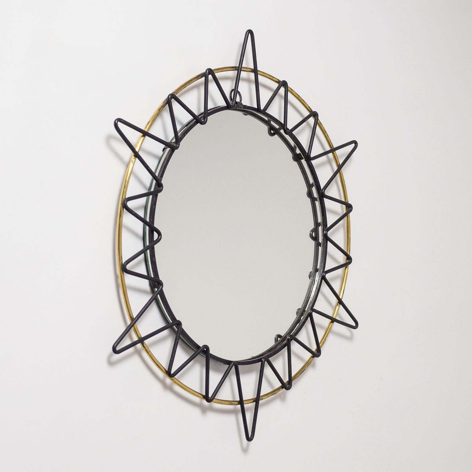 Fine French artisanal sunburts mirror from the 1950s. A slim brass ring with black lacquered 'zig-zag' sun rays. Fine original condition with some patina on the brass and original lacquer. Mirror diameter is circa 10inches/26cm.