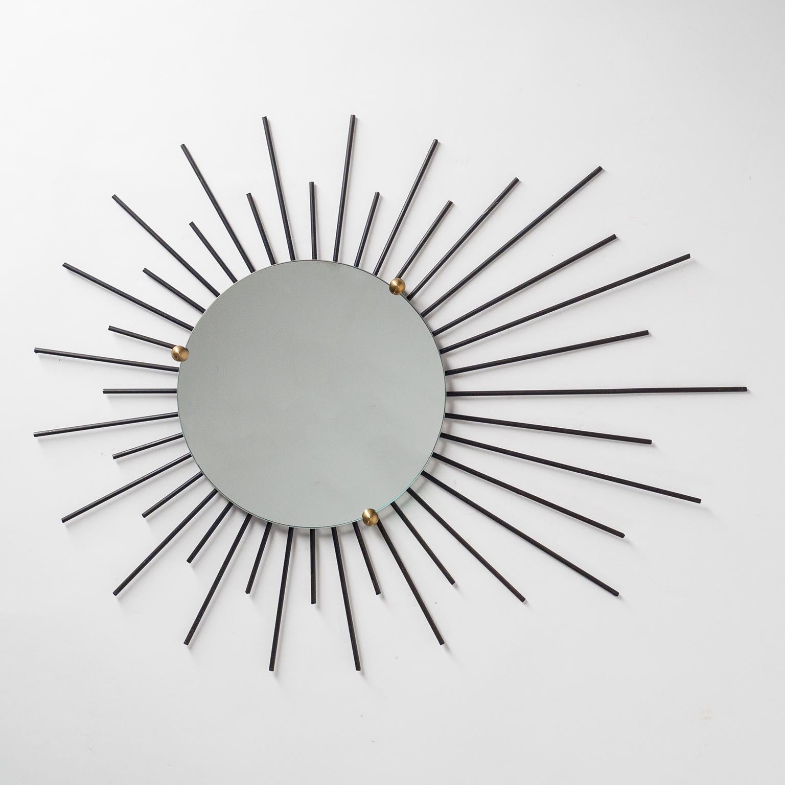 Rare modernist asymmetrical sunburst mirrors from France, circa 1960. Very graphical and dynamic modernist design with black lacquered rays and three solid brass knobs that hold the mirrors in place. Diameter of the mirrors is 26cm/10.4inches. Light