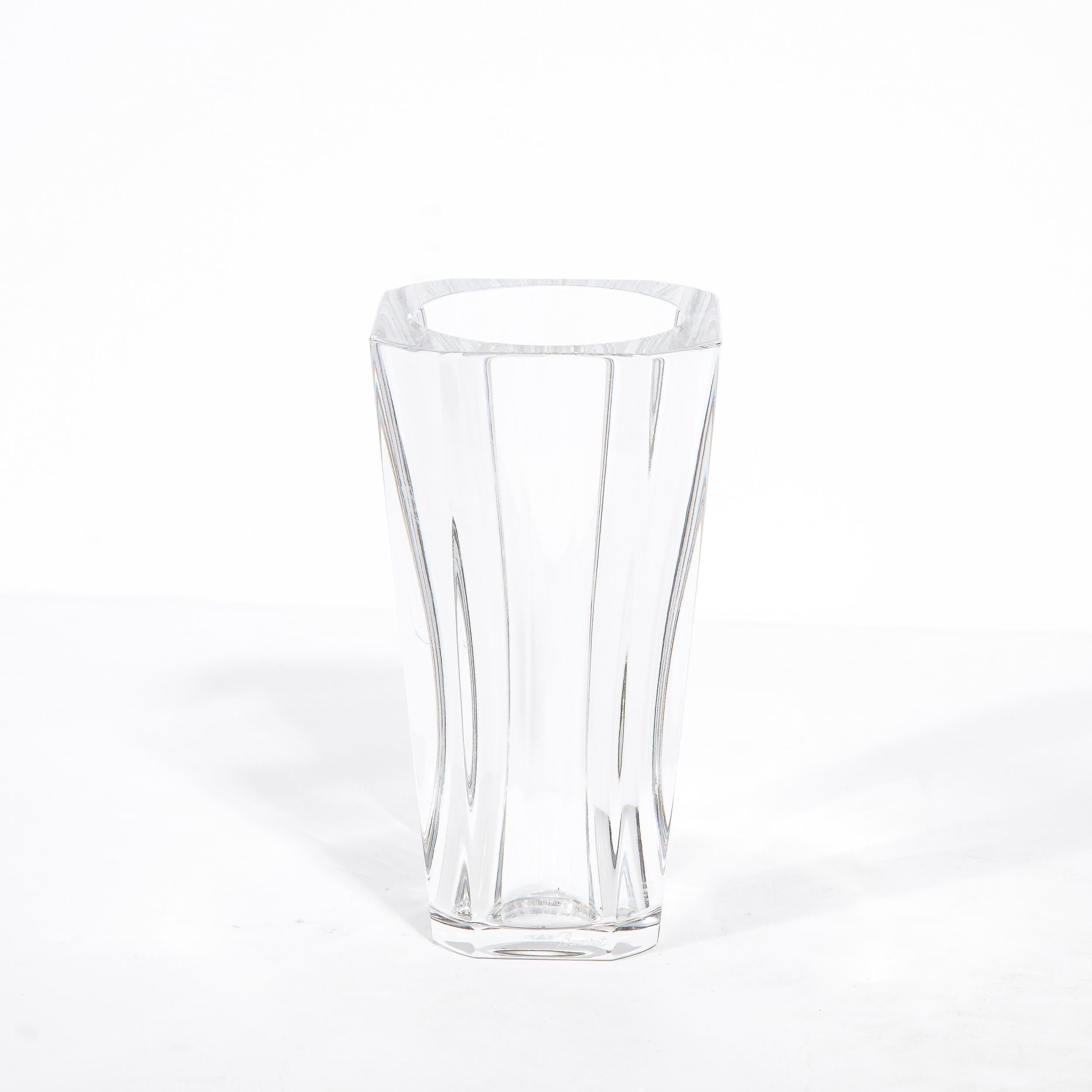 This stunning modernist vase was realized by Baccarat- one of the world's premiere makers of crystal products since 1865. The piece features a slightly rounded, cylindrical body that flares subtly at top and bottom creating a subtle hour glass form.