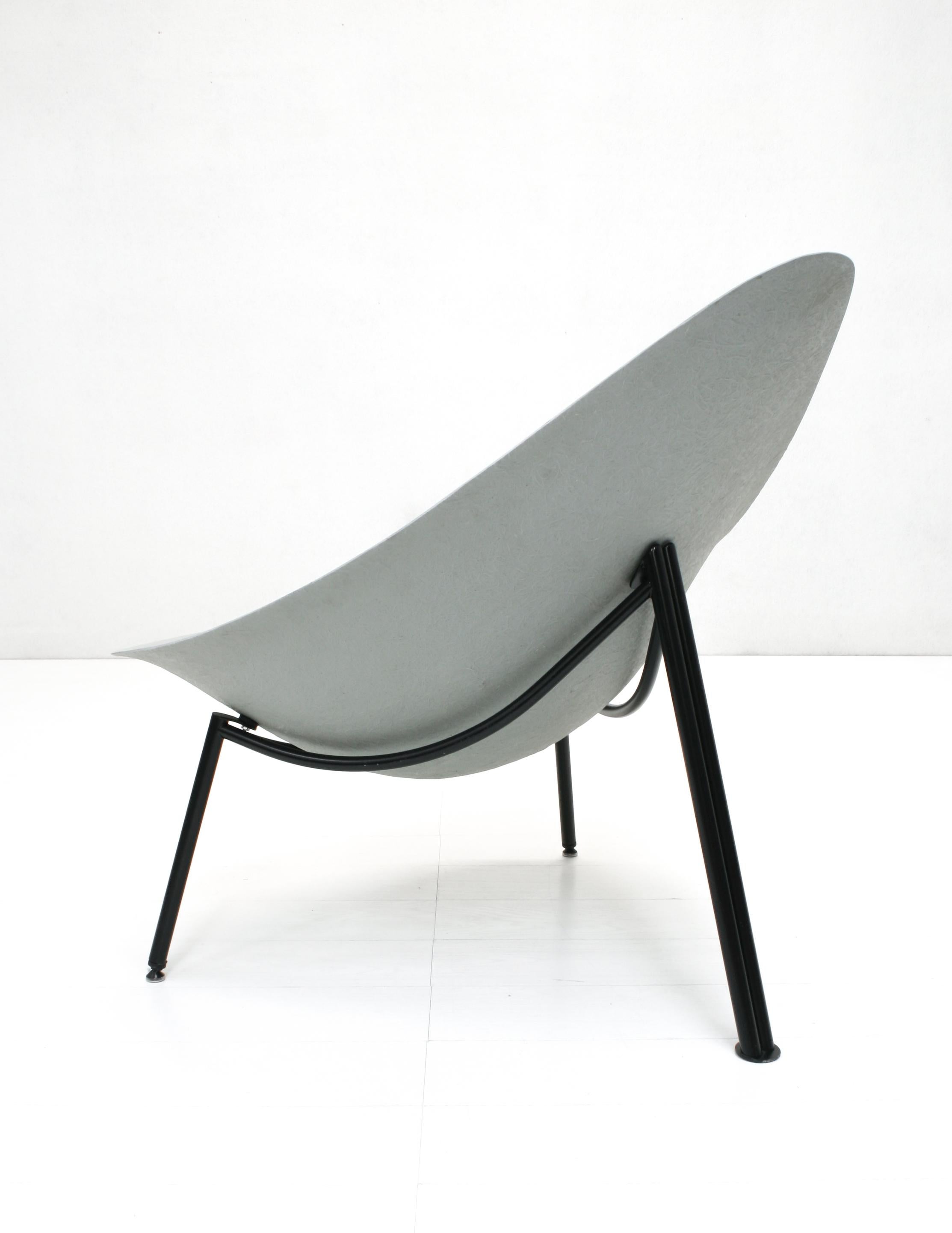 The Mérat fiberglass lounge chair, originally designed in 1956 comes in a grey shell on a black steel tube tripod frame.

This version is more recent but shows a clearly visible strong fibre structure and does have the vintage French mondernist
