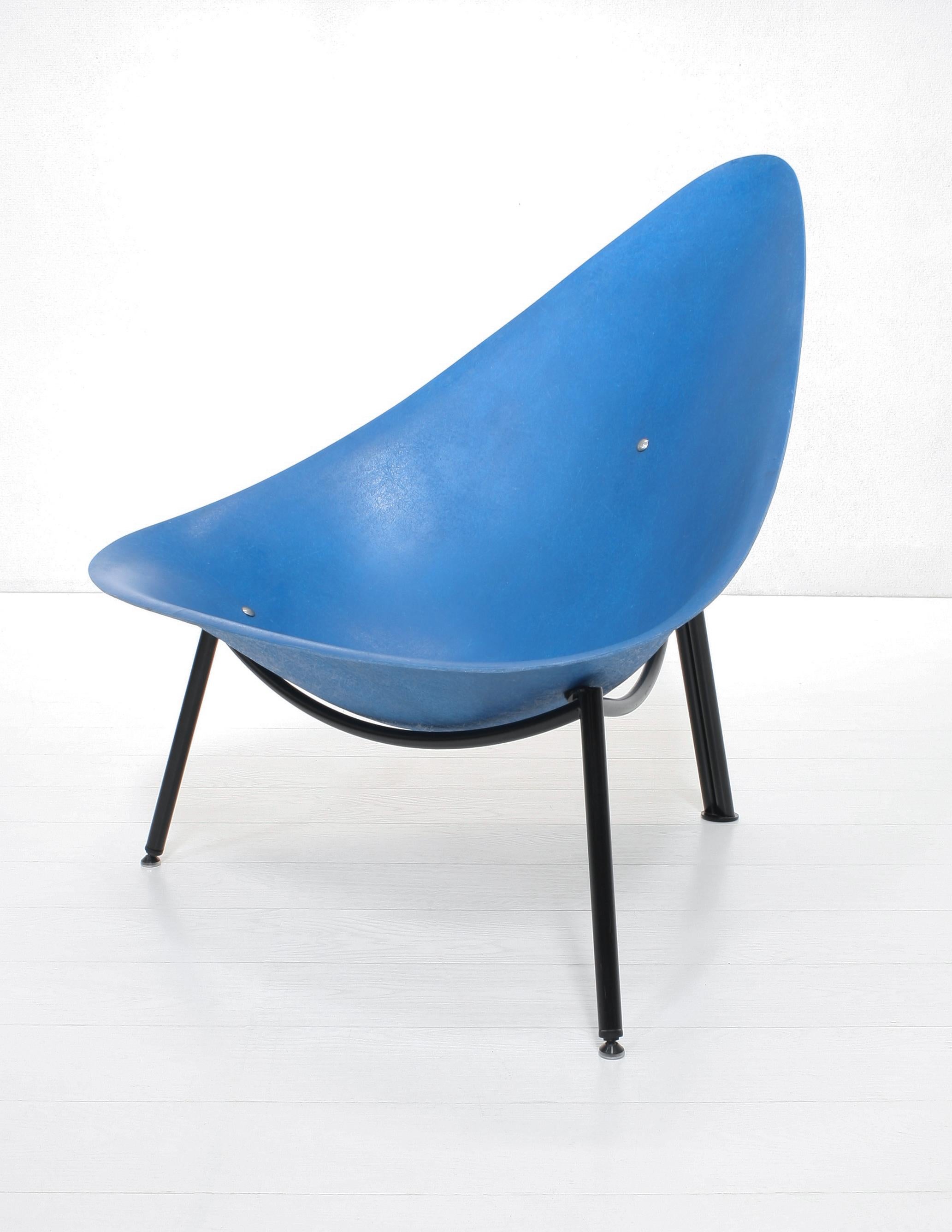 The Mérat fiberglass lounge chair, originally designed in 1956 comes in a blue shell on a black steel tube tripod frame.

This version is more recent but shows a clearly visible strong fibre structure and does have the vintage French mondernist