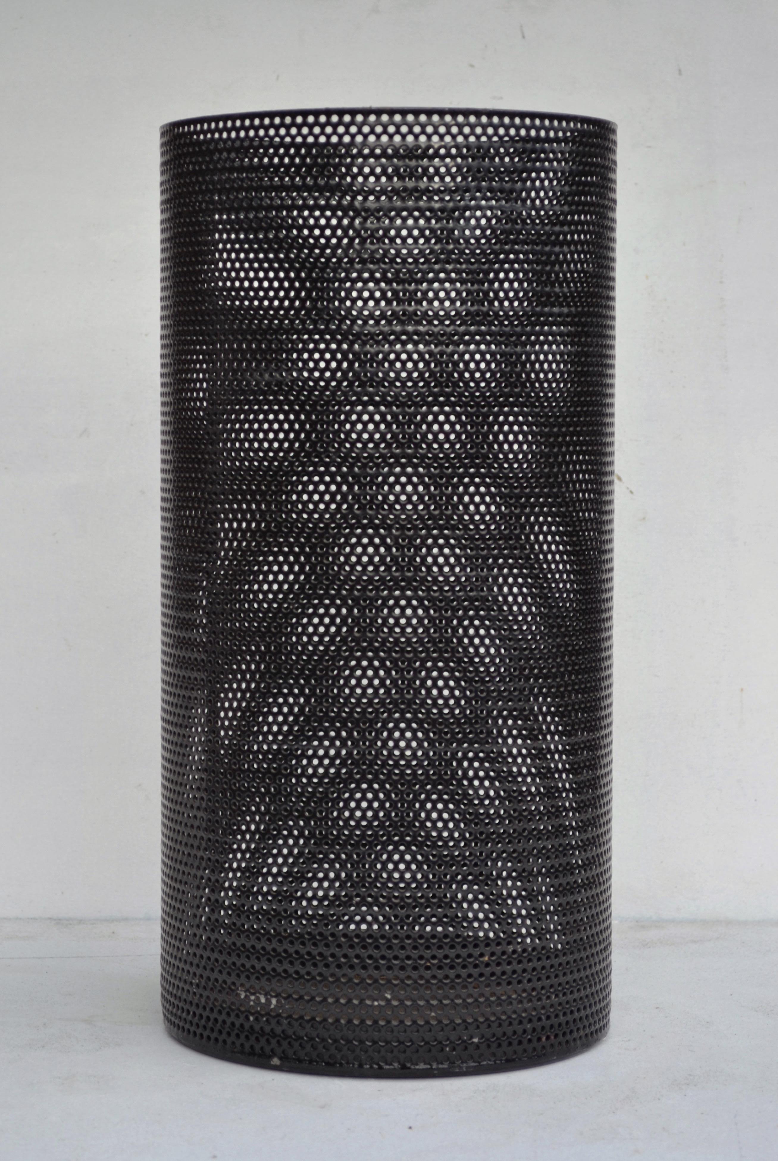 A refined example of French post-war metalwork, this 1950s umbrella stand features a cylindrical body in finely perforated, black-lacquered steel. Its rhythmic perforation and clean silhouette place it firmly within the design vocabulary associated
