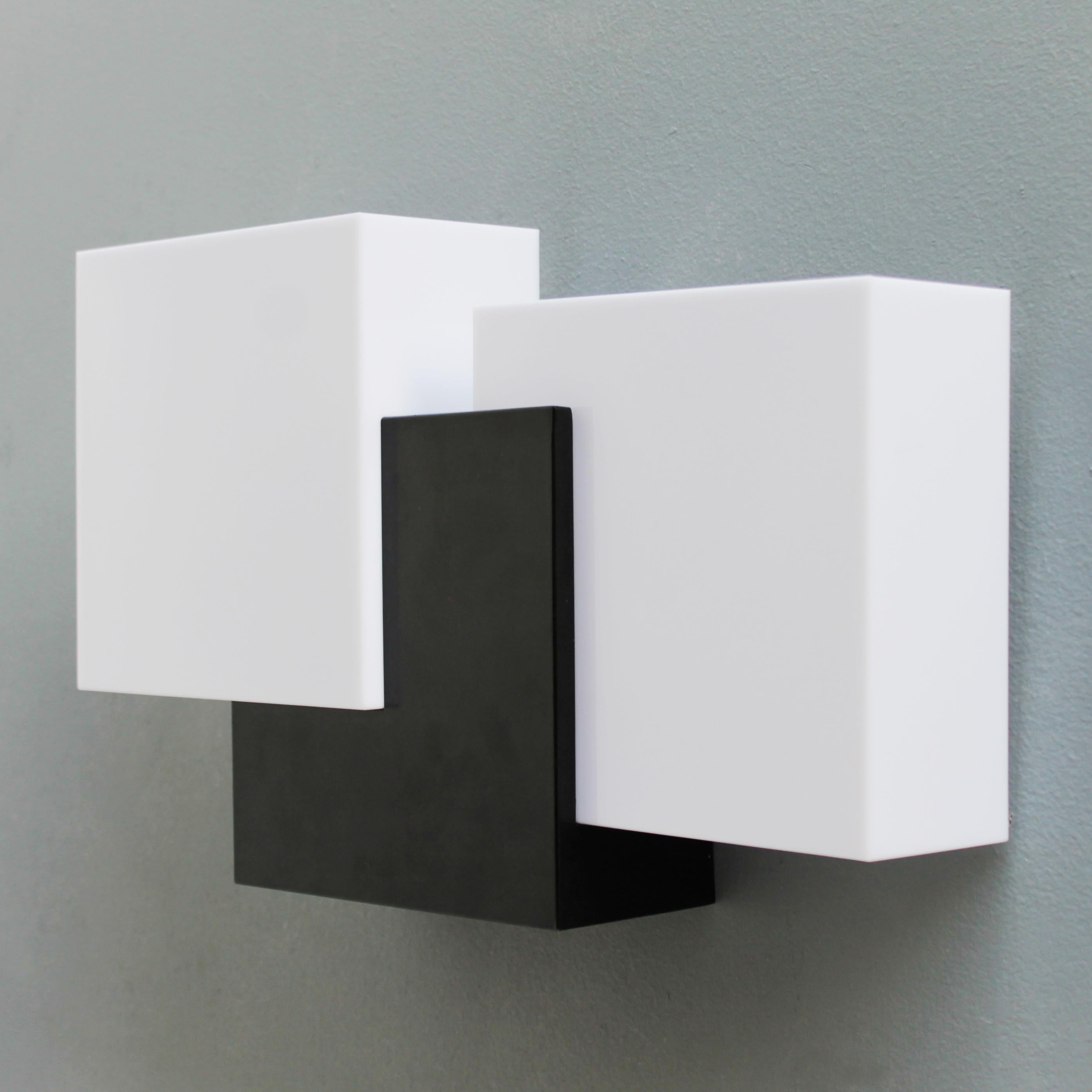 Rare sculptural modernist wall lamp attributed to Maison Arlus, manufactured in the late 1950s in France. Two acrylic light boxes and a black lacquered metal fixture in a sculptural setting. 
The electrical parts have been renewed as well as the