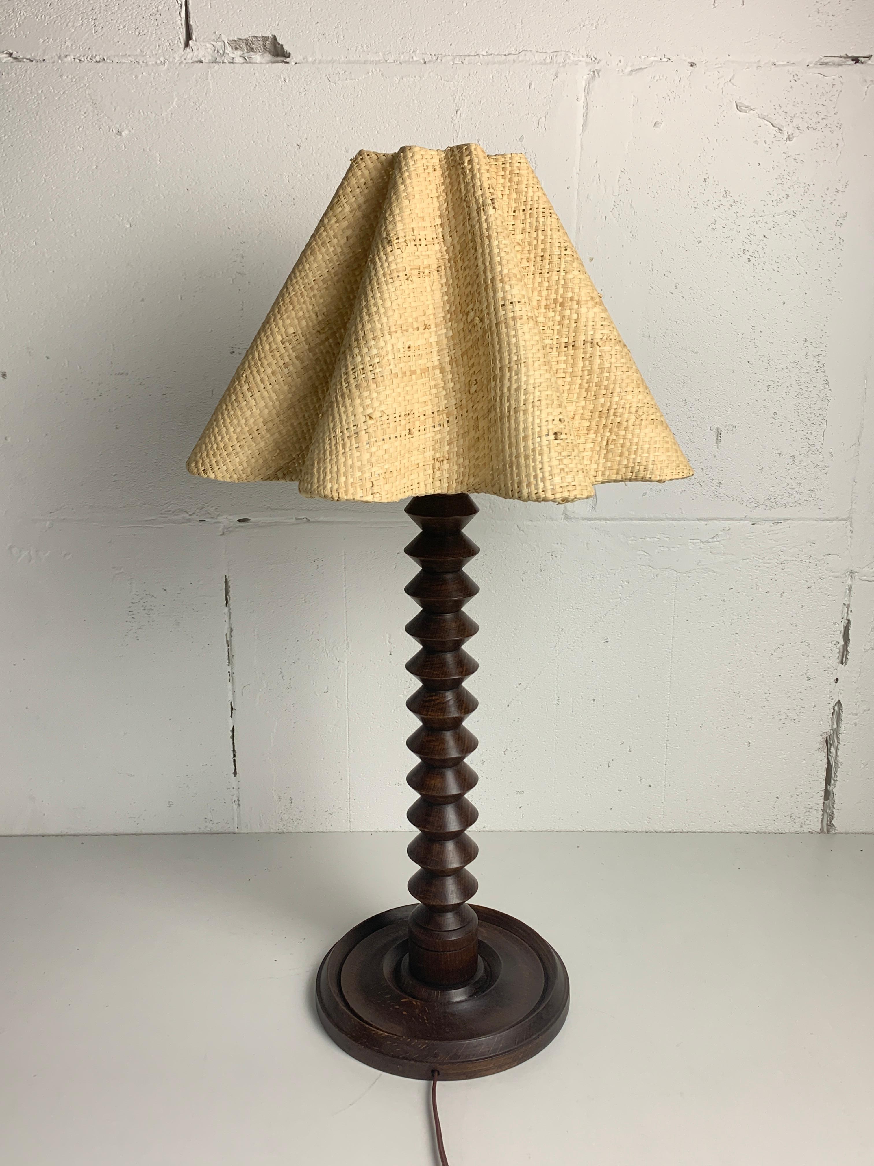 Magnifique lampe de table moderniste française avec un nouvel abat-jour en raphia, vers les années 1940-1950. Ces lampes sont souvent nommées dans le style de Charles Dudouyt. Le bois est dans un bel état patiné comme on peut le voir sur les photos.