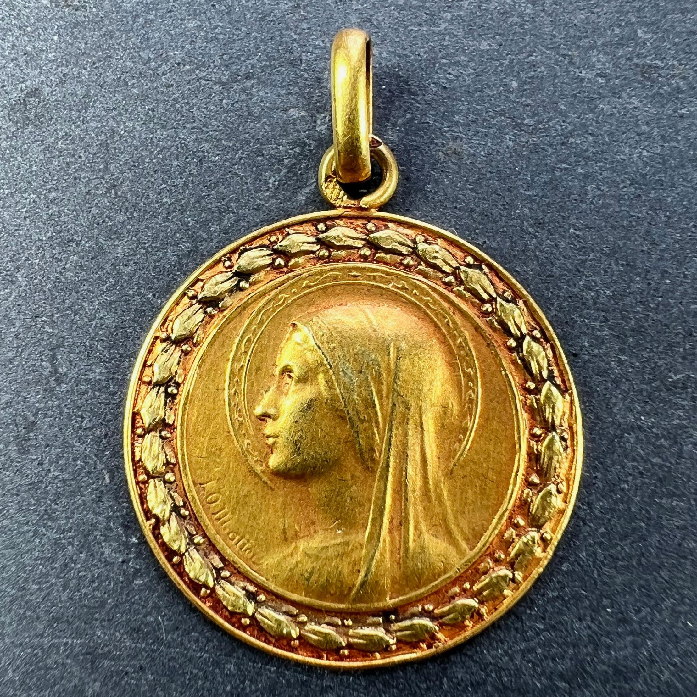 A French 18 karat (18K) yellow gold pendant designed as a round medal depicting the Virgin Mary in profile with a halo and a laurel leaf surround. Signed LO Monet. Stamped with the eagle’s head for French manufacture and 18 karat gold with a partial