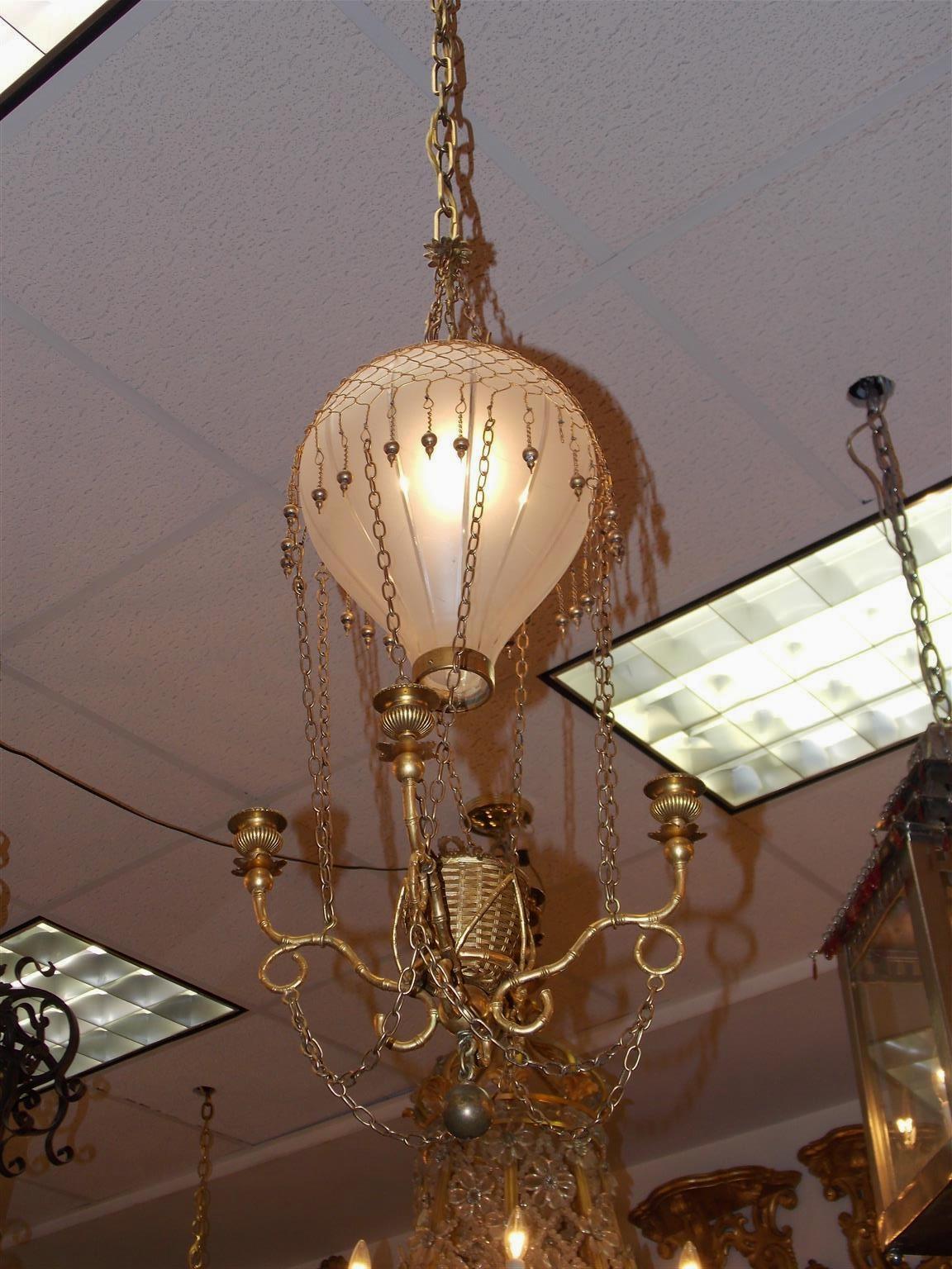 French Montgolfier gilt bronze and frosted etched glass balloon hanging hall chandelier with centered woven floral and ribbon basket, cascading netting, four exterior bamboo scrolled candle arms and terminating with a centered lower gilt brass ball.