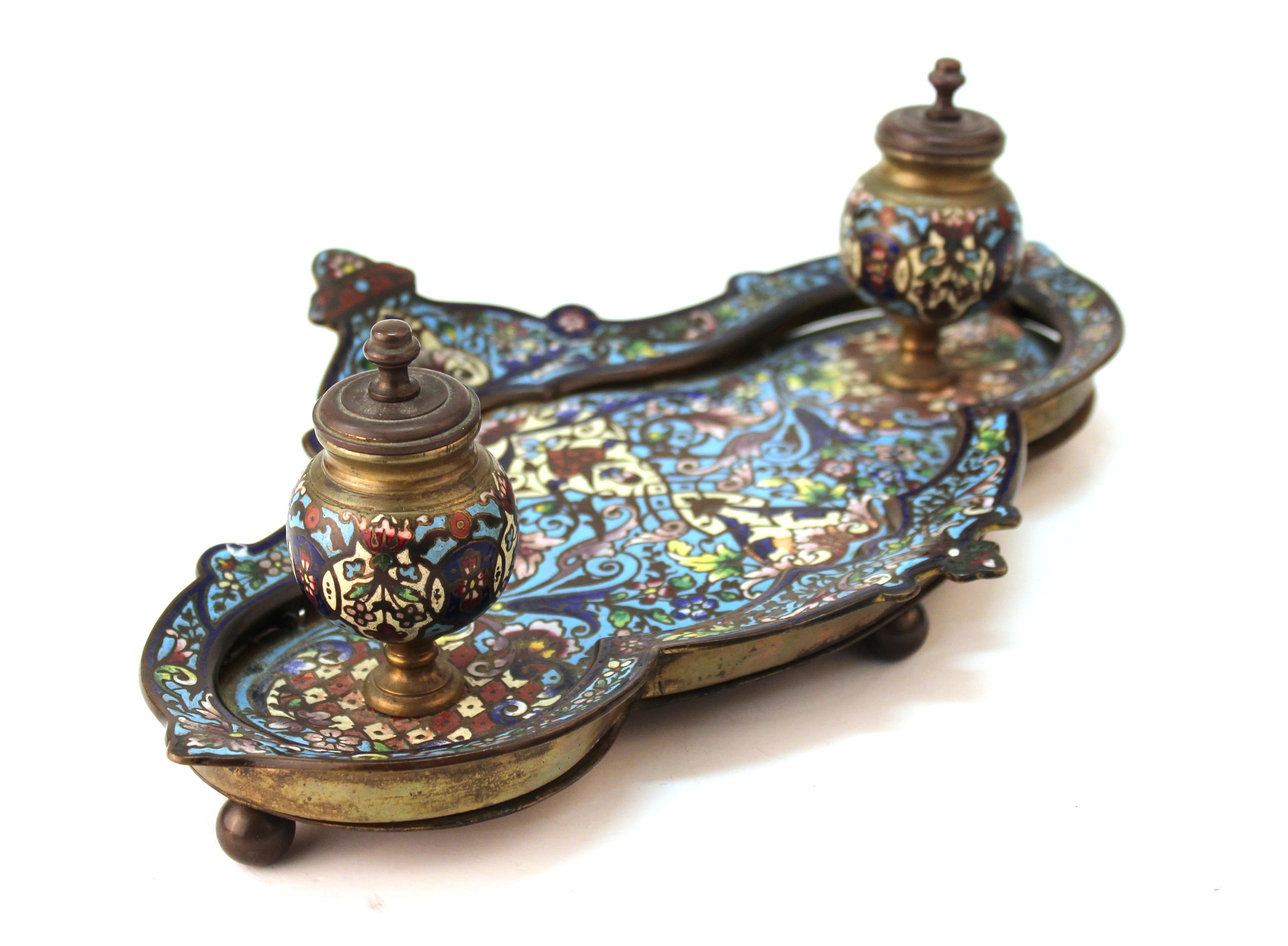 French 19th century Moorish style double inkwell and pen tray made in enameled champlevé bronze with ornate and colorful floral and foliage enameling to the tray and the bodies of the inkwells. Made in France, circa 1850s. The tray bottom is warping