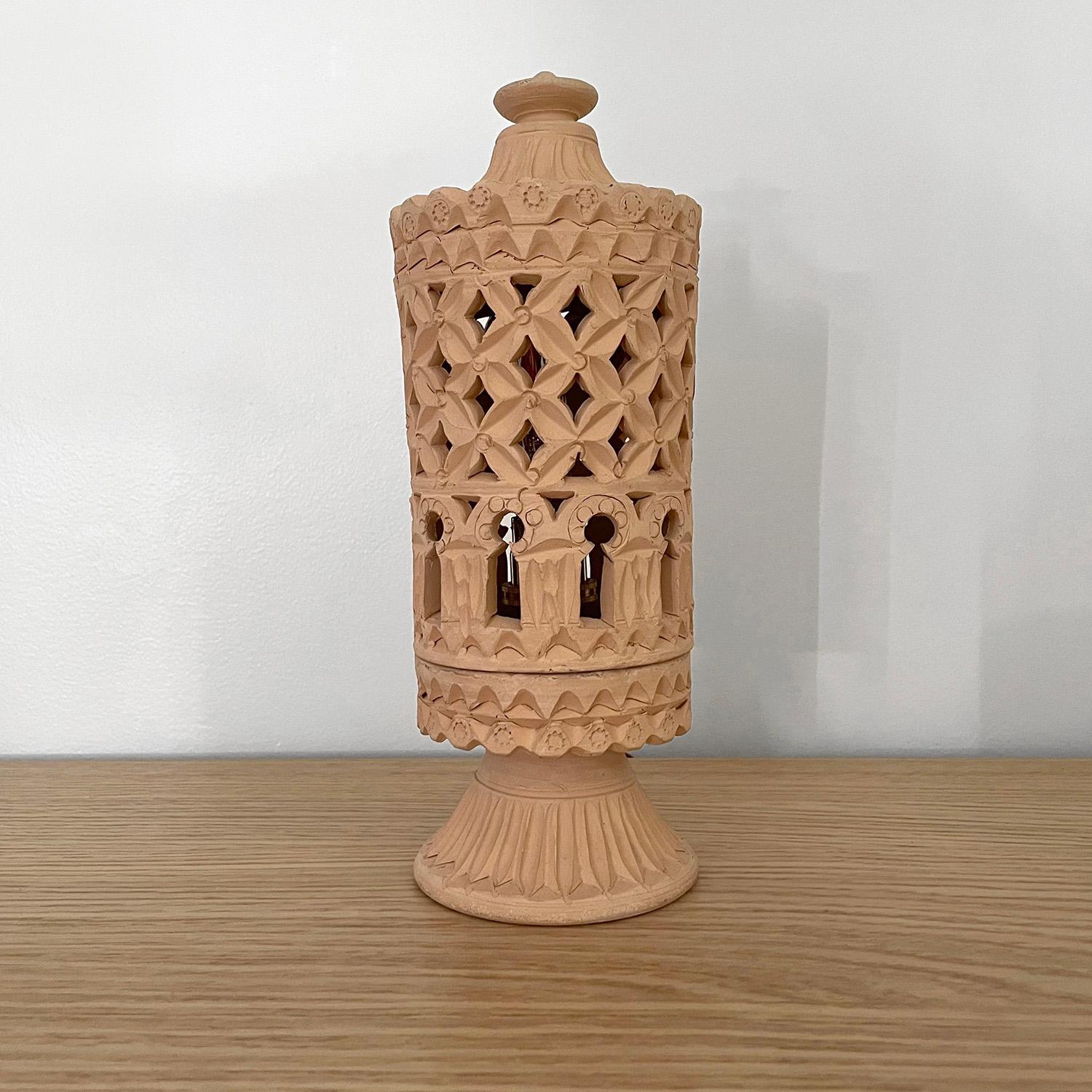 French Moroccan terracotta lamp
1970s
Organic composition and feel
Beautifully hand sculpted piece
Geometric cut outs create an illuminated light pattern
Delicately etched rosette detail around the base
Newly rewired
Single socket candelabra base 


