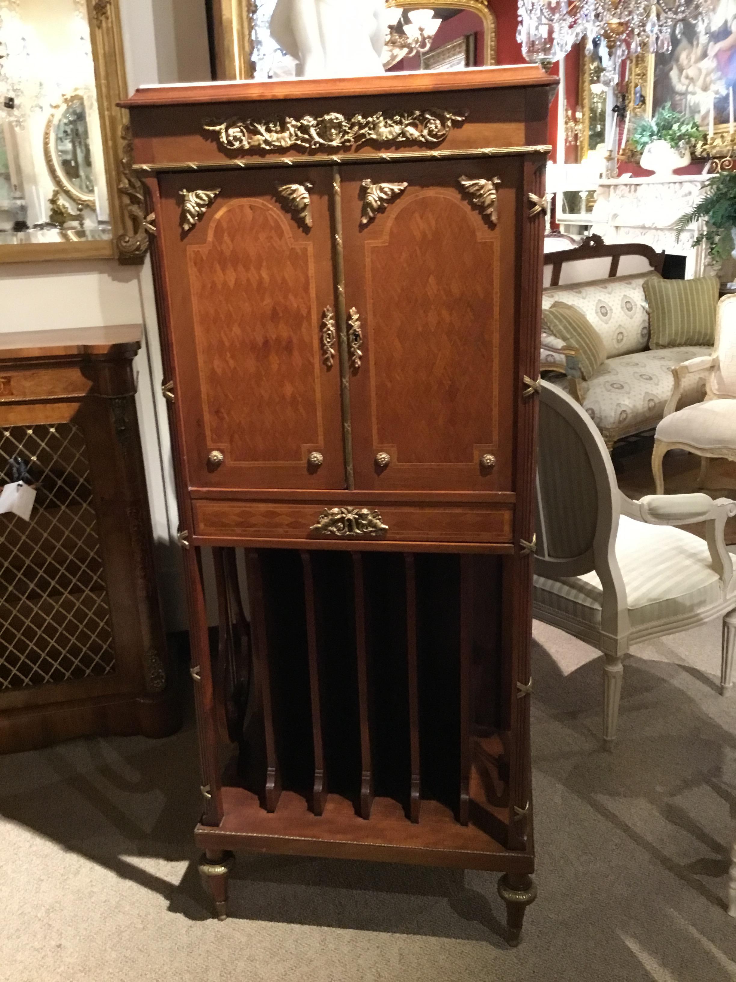 Elegant and petite music cabinet with marquetry in walnut and satinwood. Two doors open to
Shelves for music. One drawer below opens for more storage. Divided panels are vertical to
separate additional musical books.
