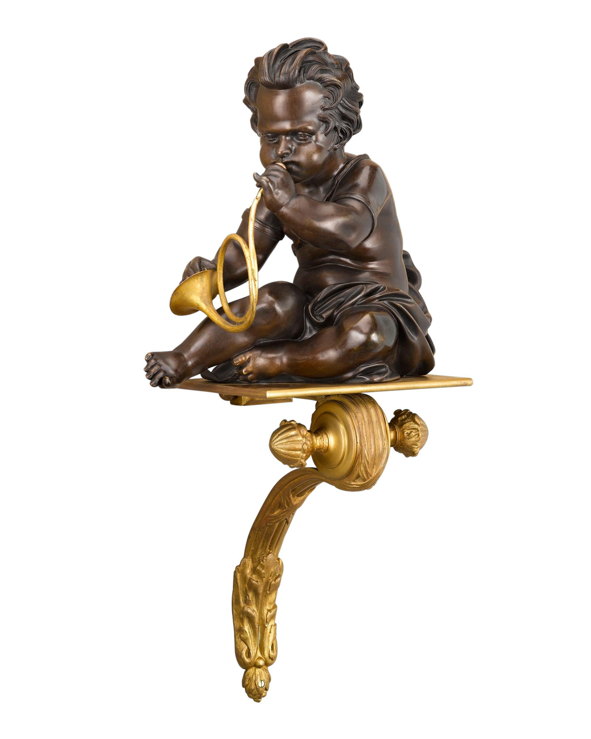 Un duo de putti enclins à la musique joue d'un cor et de cymbales dans cette paire rare et attrayante de supports muraux français. Les putti en bronze patiné reposent sur de fines plates-formes en bronze doré en forme de volutes élégantes. Vers