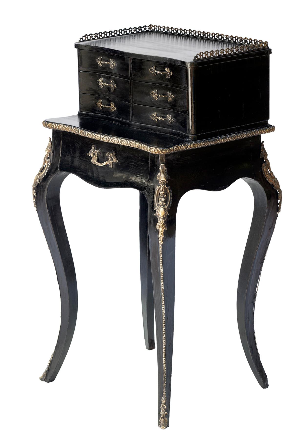 Ebonized Napolean III period Mahogany petite dressing table for jewels & other small valuables. Six small drawers with decorative pulls and lined drawers rests on a small table top below which there is a spacious lined drawer.

Bronze gallery on top