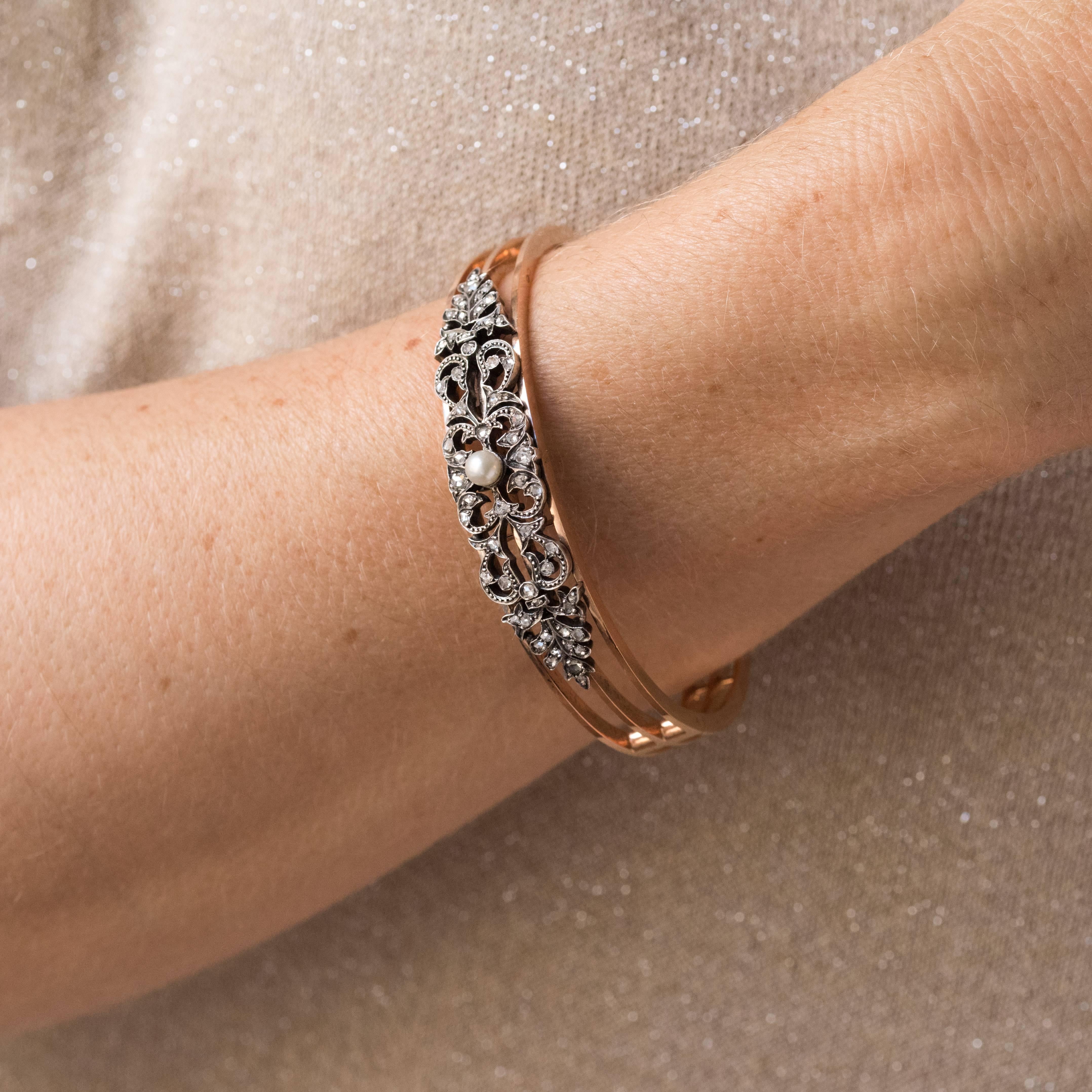 Bracelet in 18K rose gold and silver, owl hallmark.
A hinged bracelet consisting of three separate but connected gold bands. Decorated at the top with an openwork floral design incorporating rose cut diamonds and a fine pearl at the centre. The