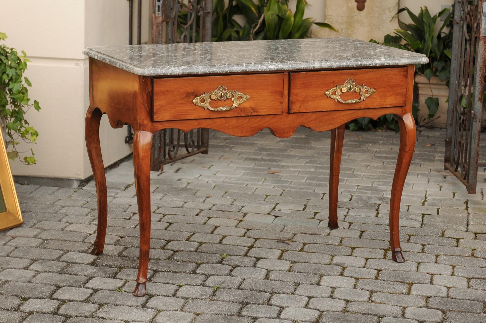 A French Napoleon III period walnut console table from the mid-19th century, with grey veined marble top, two drawers and cabriole legs. Born in France in the early years of Emperor Napoleon III's reign, this exquisite console table features a